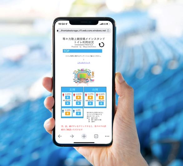 手元のスマホからトイレの混雑状況を確認する様子