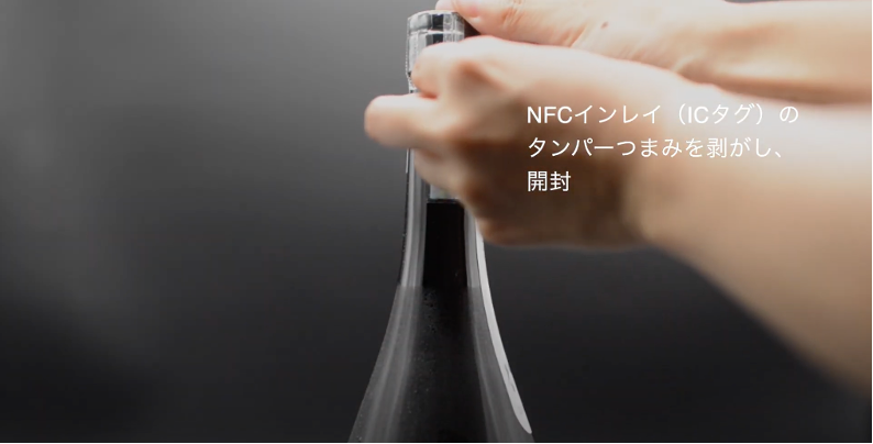 NFCタグの“つまみ”部分（糊殺しエリア・上下ミシン目あり）を指で掴み右側にスライドさせて千切ります