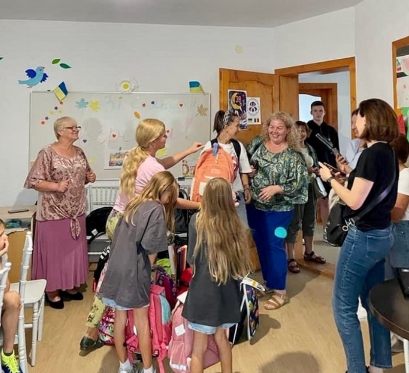 子供たちに学習用カバンをプレゼントする様子