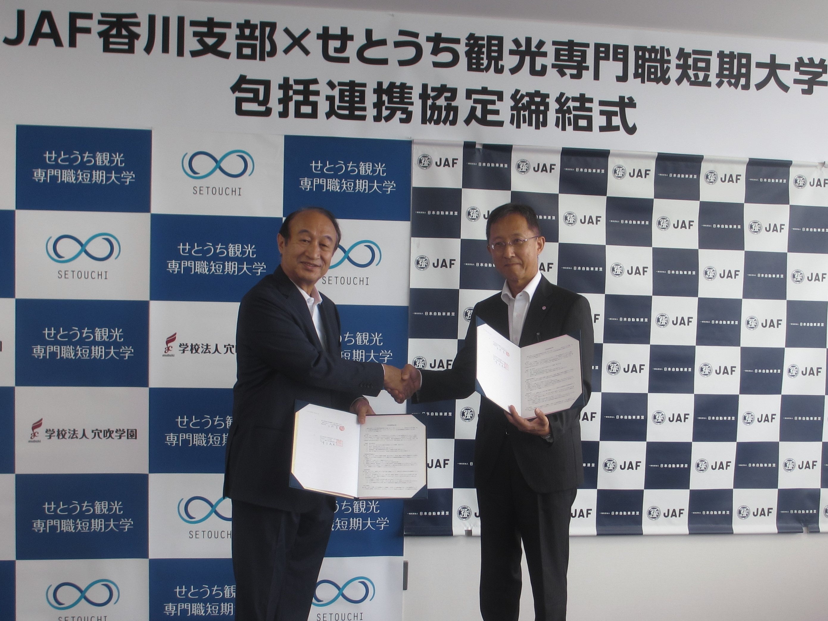 左：青木義英学長　右：出野育事務所長