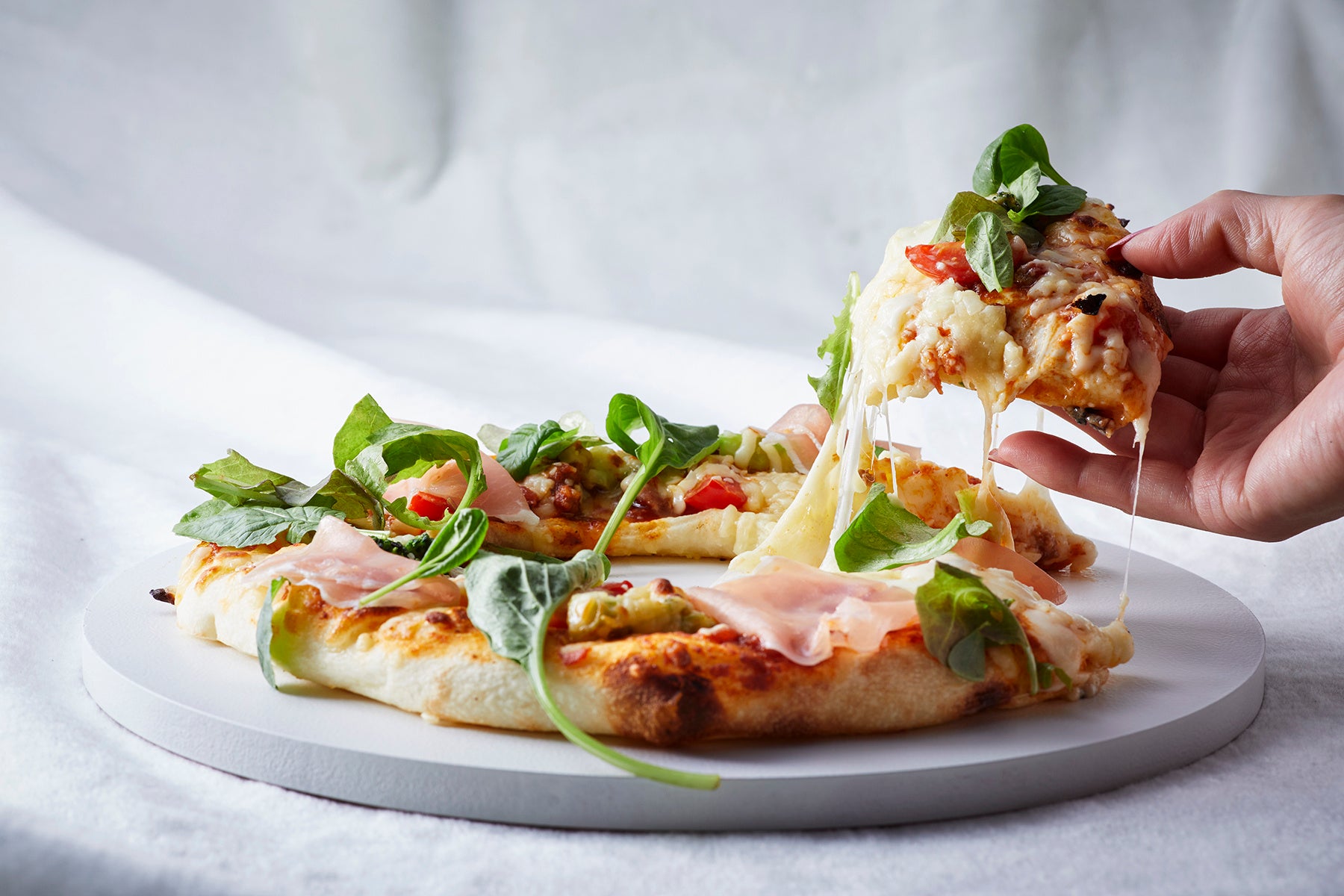 クリスマスリースをイメージし、生ハム、ベビーリーフ、チーズをオーナメントに見立てトッピングしたピッツァなど、4種の季節のピッツァをご用意。