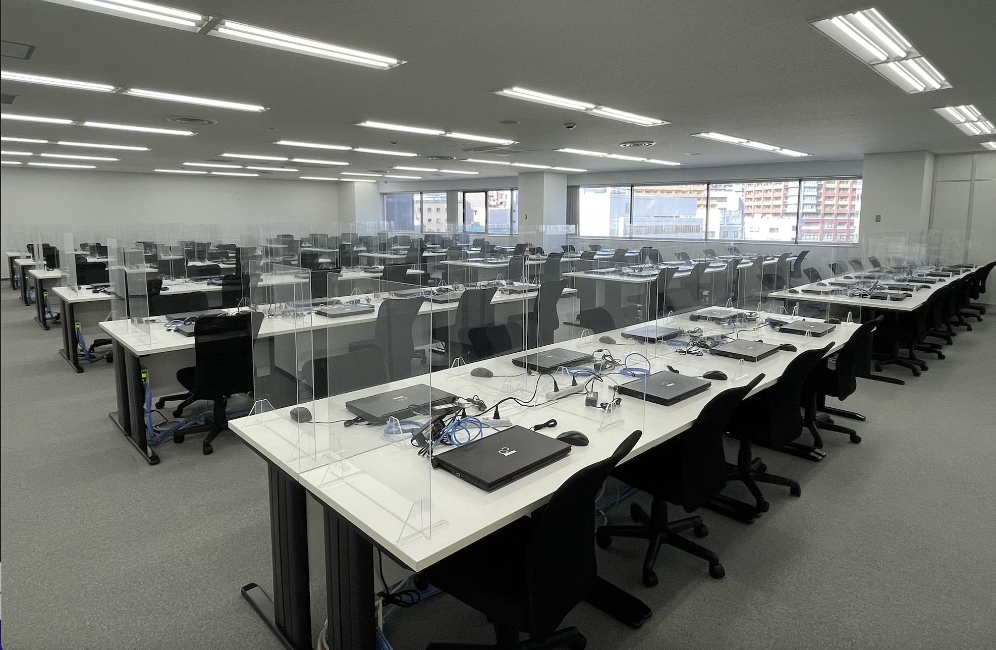 106席の執務室。感染対策として座席の正面と左右の三方に仕切りを設置。
