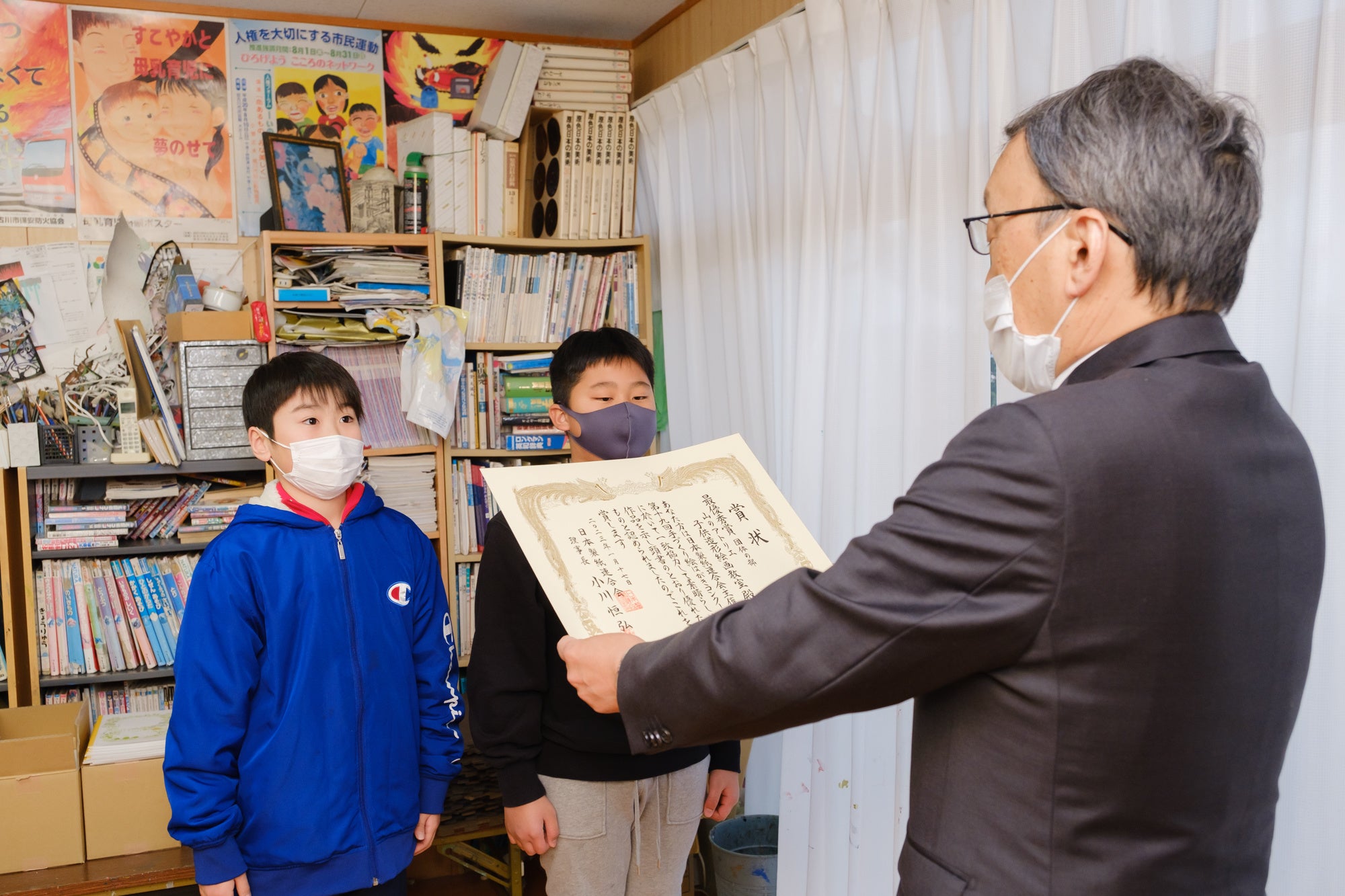 団体最優秀賞の賞状と副賞を受け取る生徒の2人