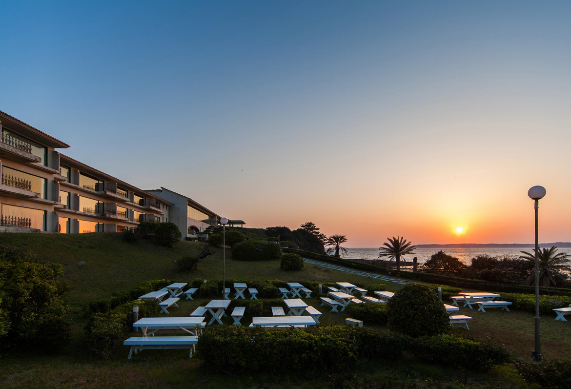 海に沈む夕日とホテルガーデン