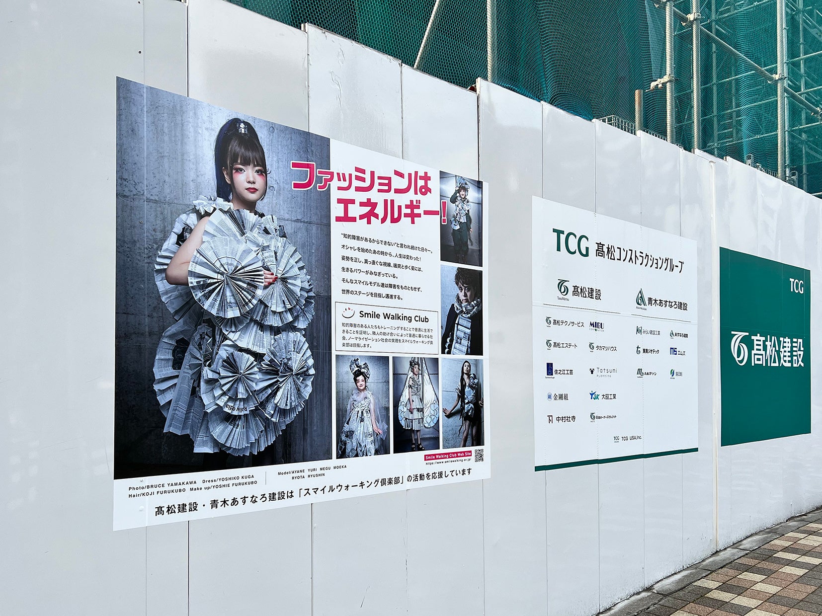 （仮称）TCGビル新築工事現場の仮囲いに掲出された「スマイルウォーキング倶楽部」パネル