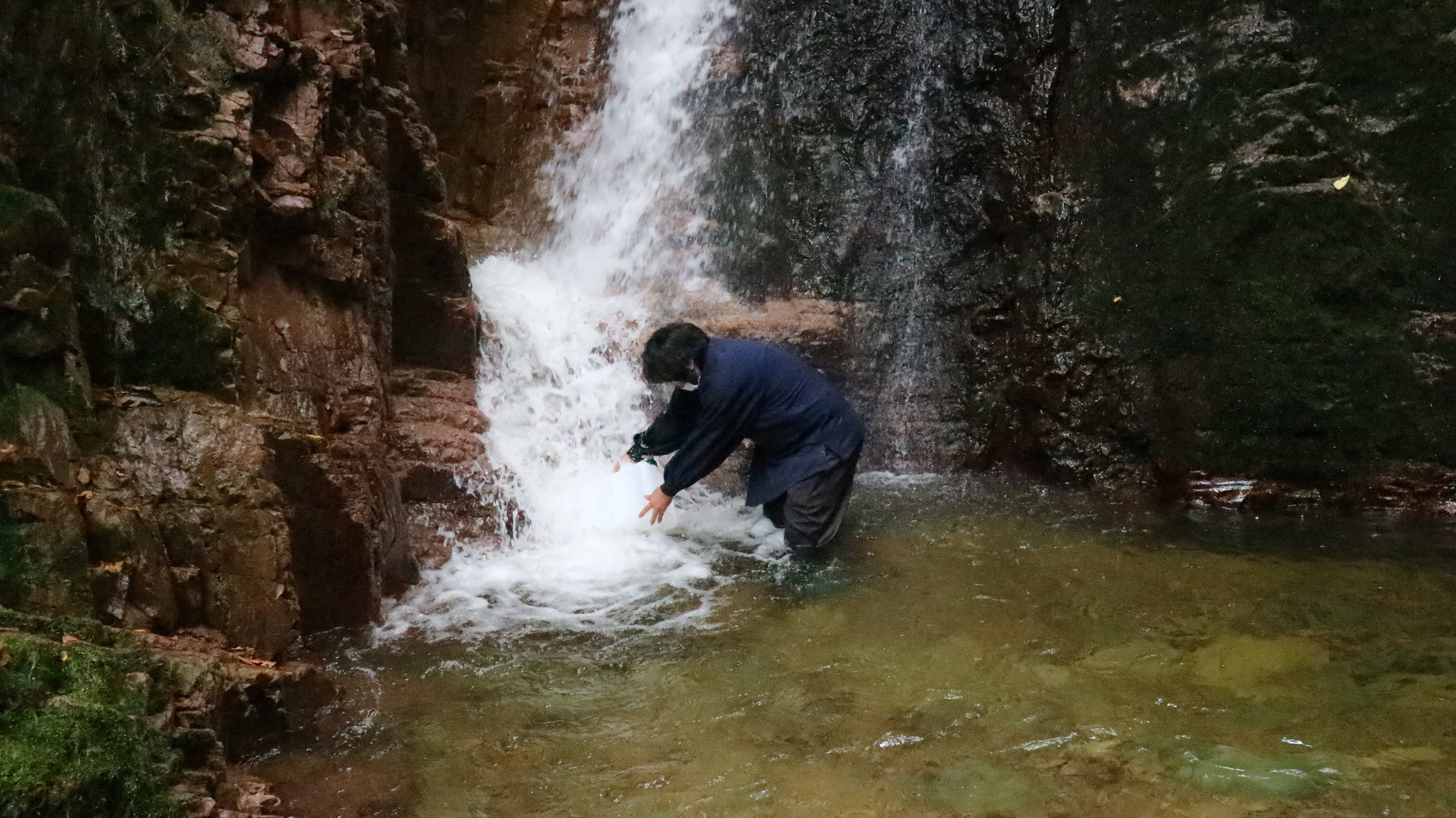 紙漉きに使う不動滝の水を汲む