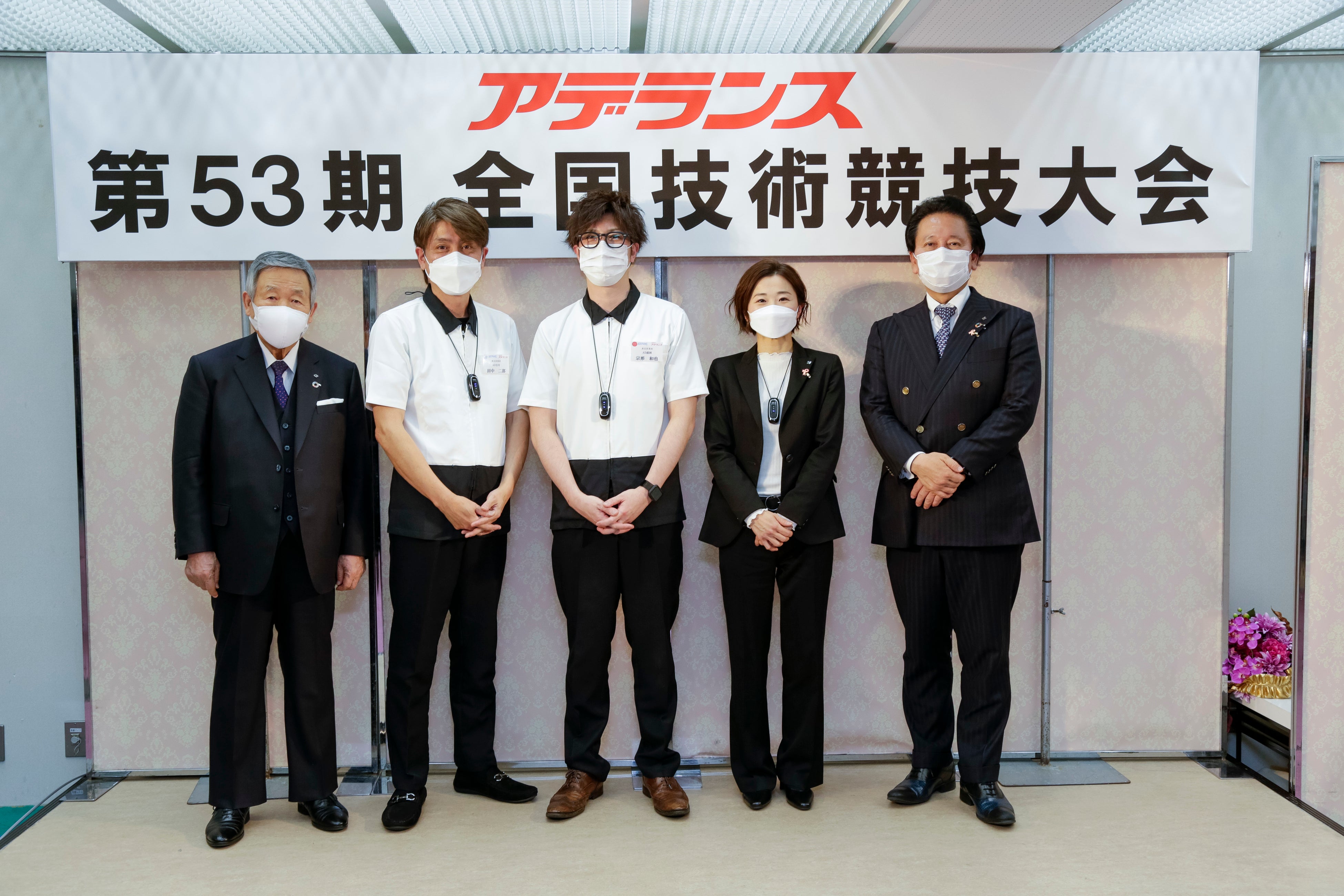 「メンズ部門」優勝者：アデランス古川　田中 二郎（左から2番目） 「レディース部門」優勝者：アデランス盛岡 宗形 和也（左から3番目） 「アドバイス部門」優勝者：アデランス成田　藤本 奈津子（左から4番目） 会長の根本（左）、社長の津村（右）と一緒に