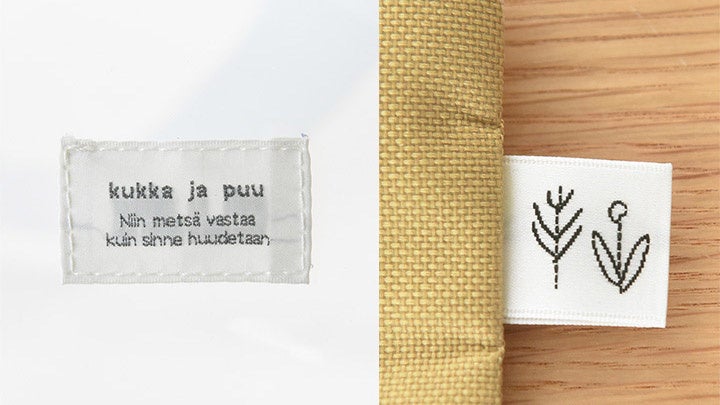 （左）デザインのアクセントになるブランドタグ（右）ポーチに取り付けた木の刺繍タグ