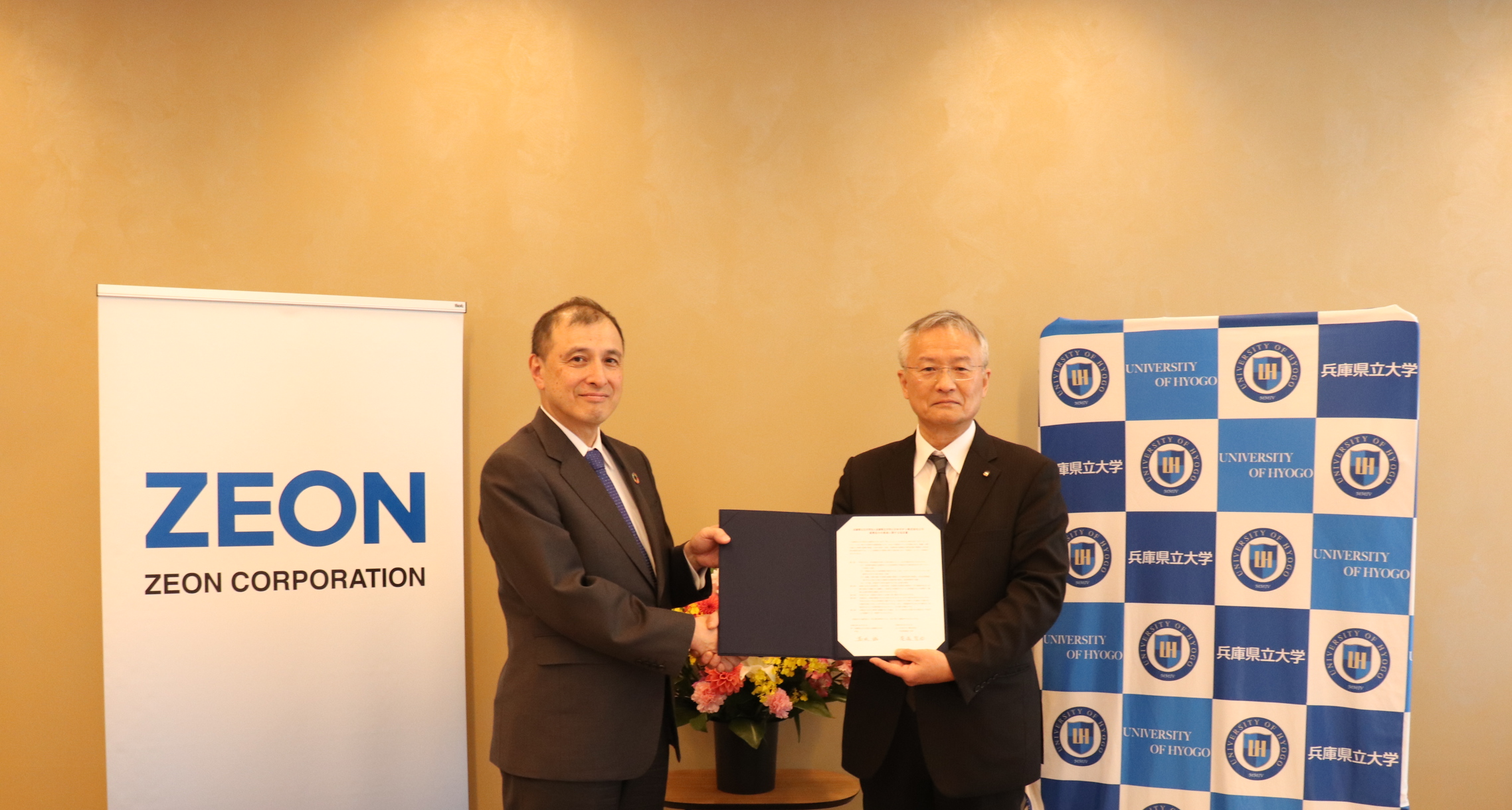 当社代表取締役社長・豊嶋（写真左）と兵庫県立大・髙坂学長