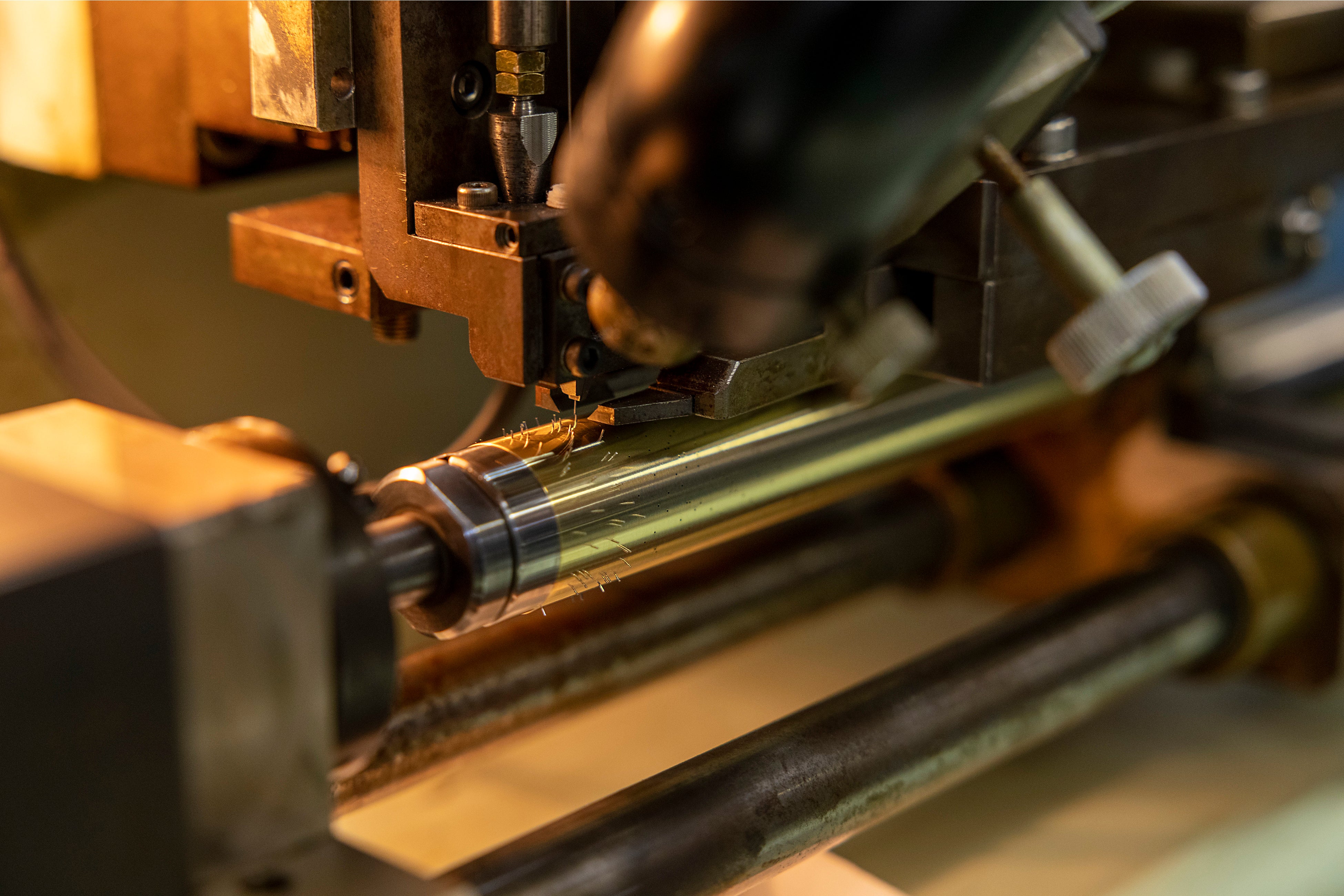 コンピュータ制御によりシリンダー（ドラム）にピンを打ち込む工程。