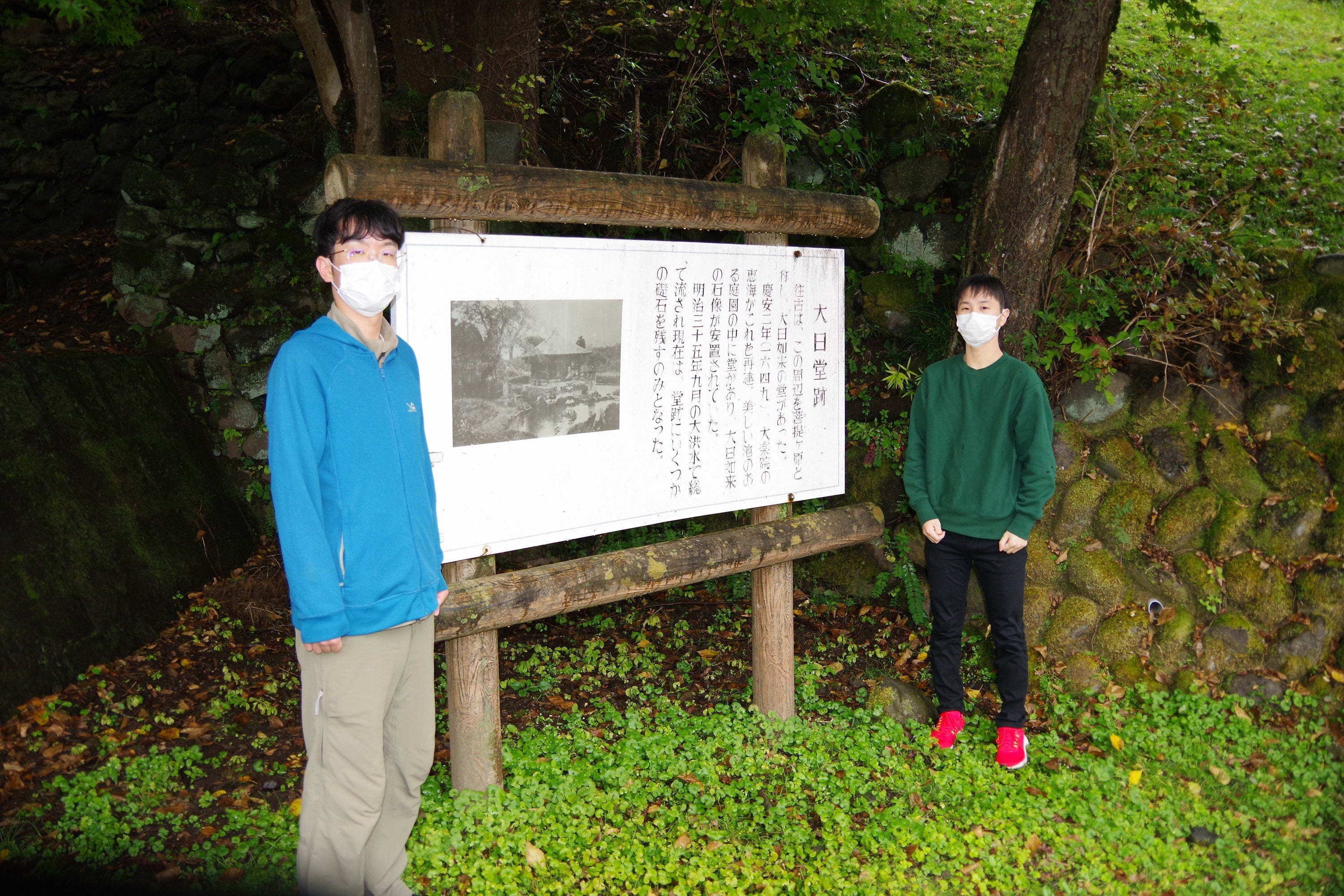 写真８　大日堂跡地にて。大谷川の川岸ぎりぎりまで敷設された跡をその目で確認してきました。写真左は本学学生の島崎君、右は小島君。2022年10月24日。宇都宮大学撮影。