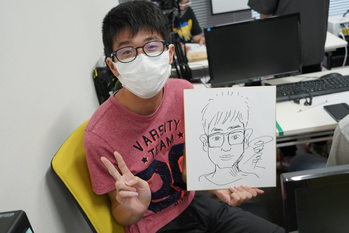 今村孝矢さんに似顔絵をかいてもらい喜ぶ利用者さん