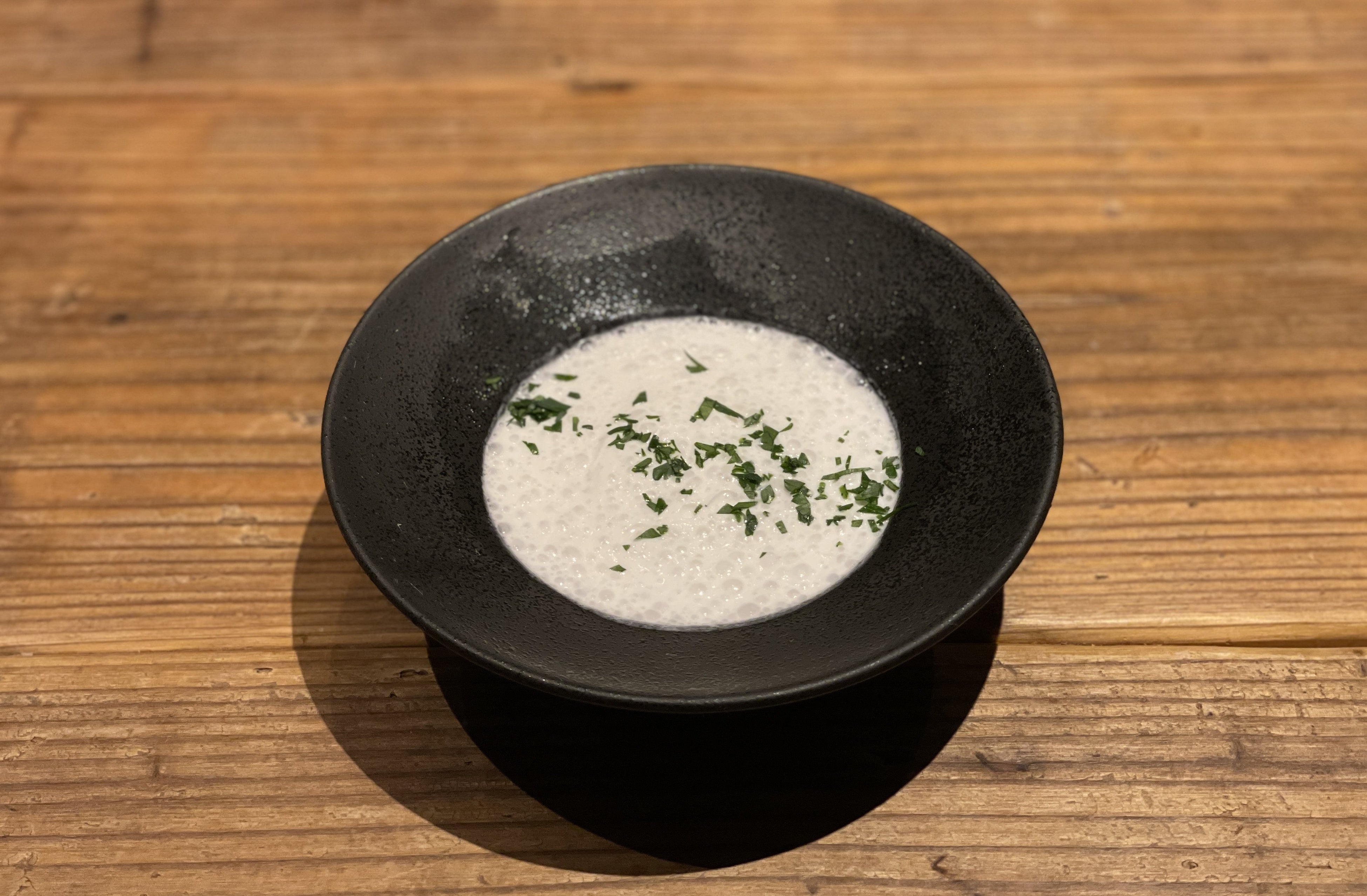 薪焼 かぶと新玉ねぎのスープ：薪でじっくり焼いたかぶと新玉ねぎで作るお口直しのスープ。ホタテのエスプーマを添えて。