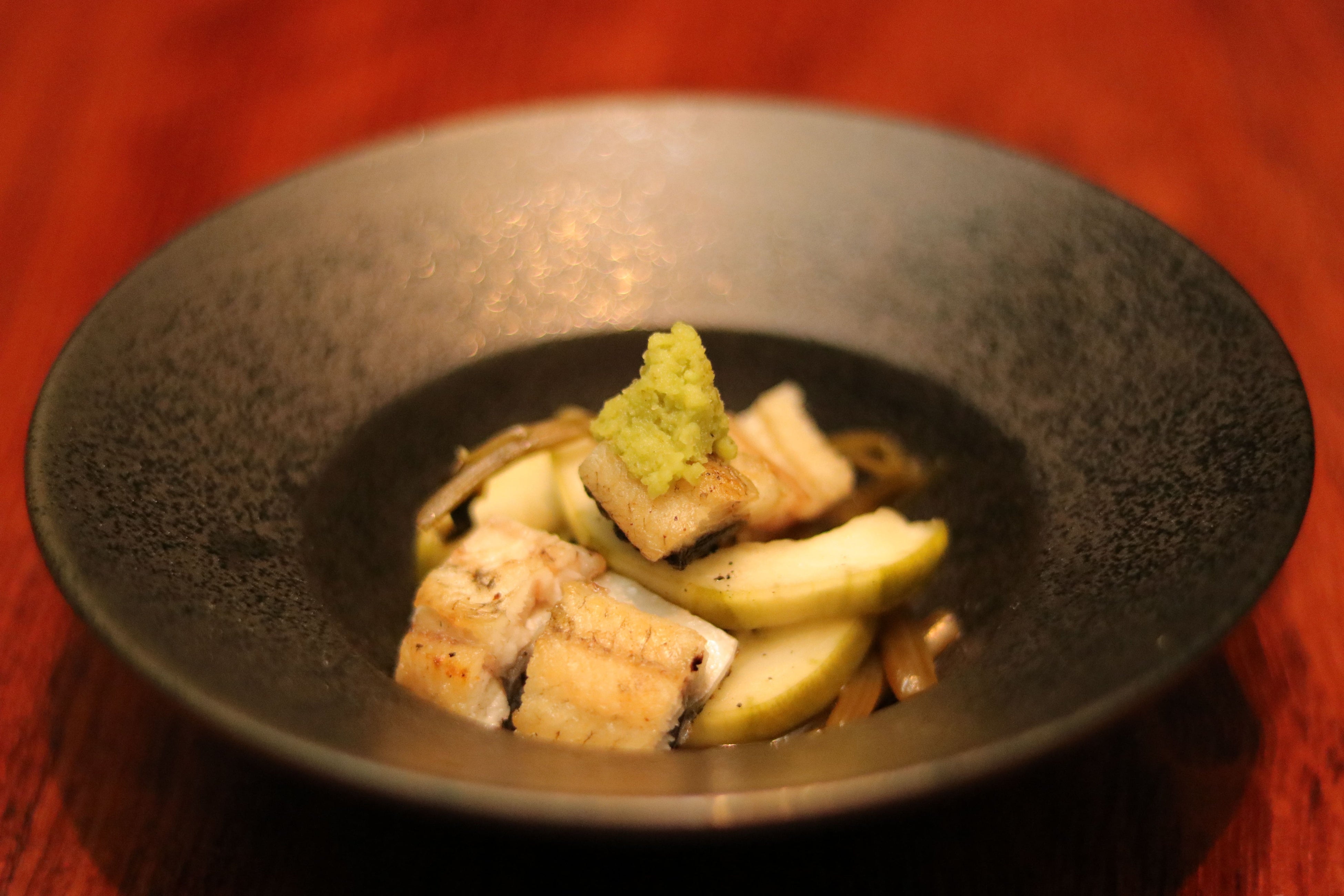 薪焼 鰻と葉わさびと白瓜：かまどで香ばしく焼いた鰻の白焼と葉わさび、白瓜の千枚漬けを和えたさわやかな前菜。