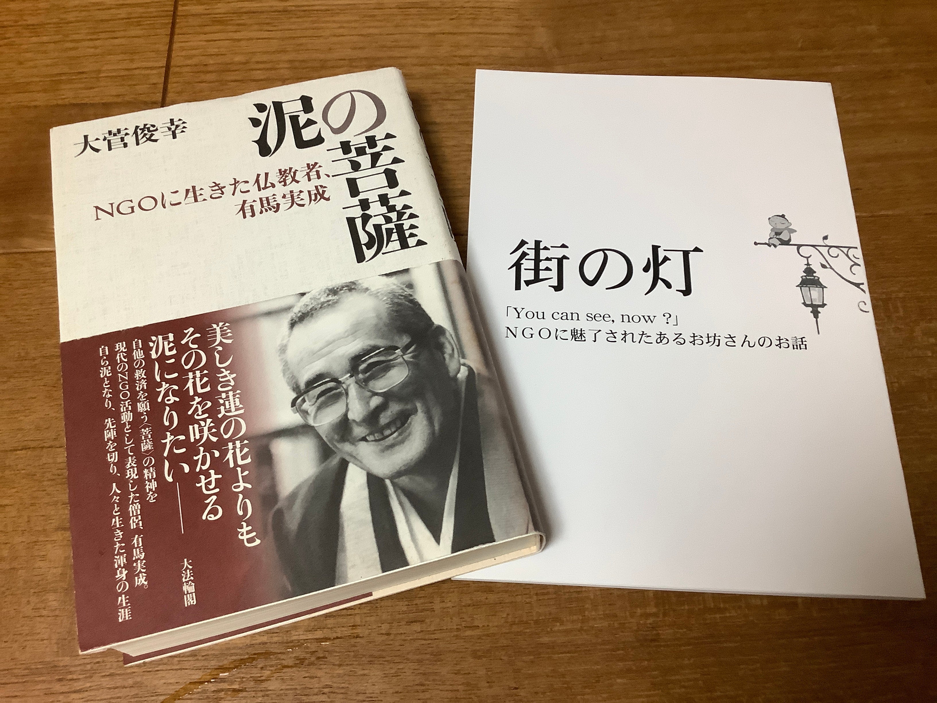 写真左：有馬実成さんの人生を辿る『泥の菩薩』登壇者の大菅俊幸さん著。&nbsp; 写真右：茂田眞澄のNGOへの想いを綴った『街の灯』。チャップリンをこよなく愛した茂田は、自身の戒名にも「街灯」と入れた。