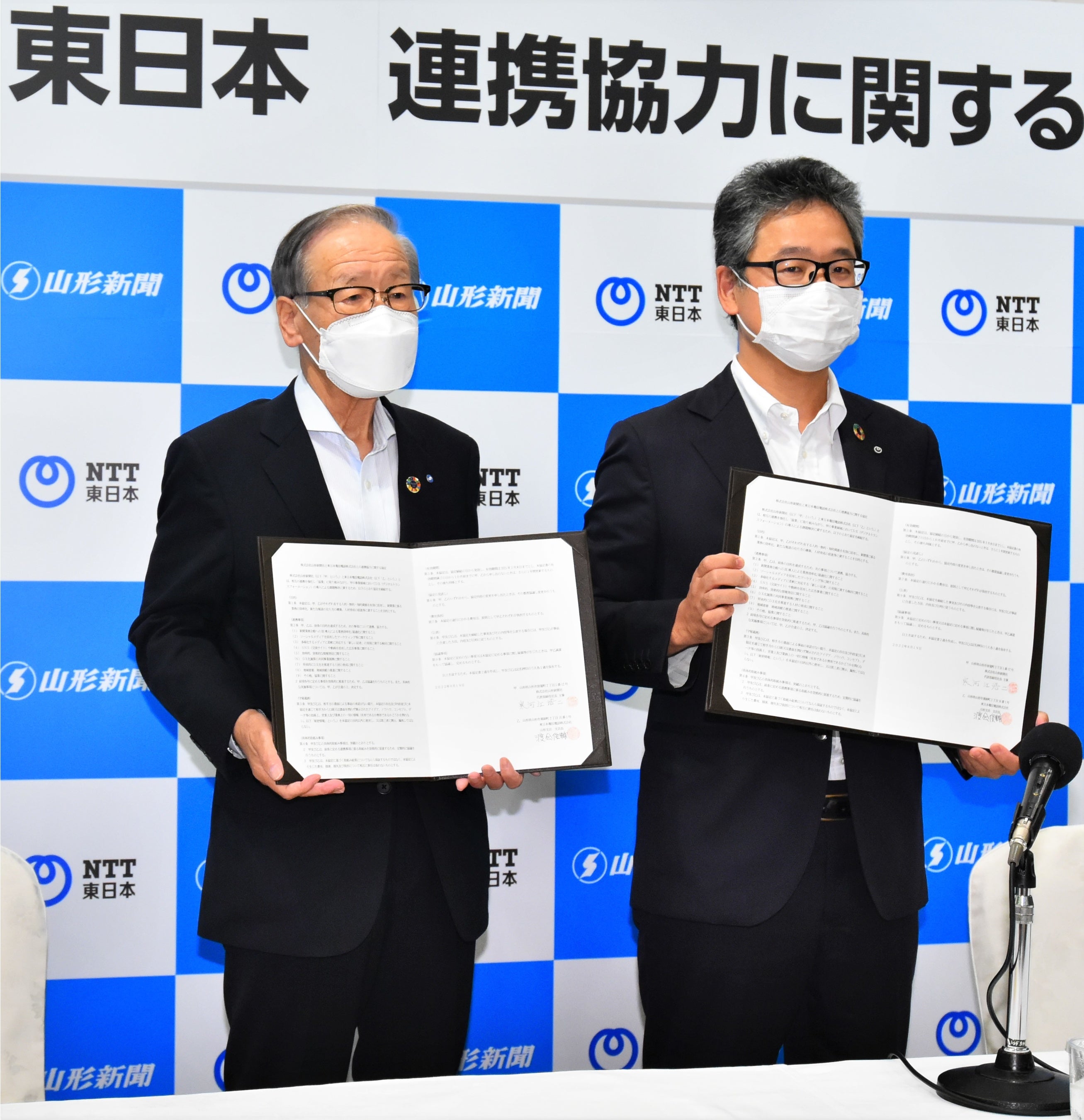 協定書を手に写真に納まる寒河江浩二山形新聞社長（左）と渡会俊輔NTT東日本山形支店長＝山形市・山形グランドホテル