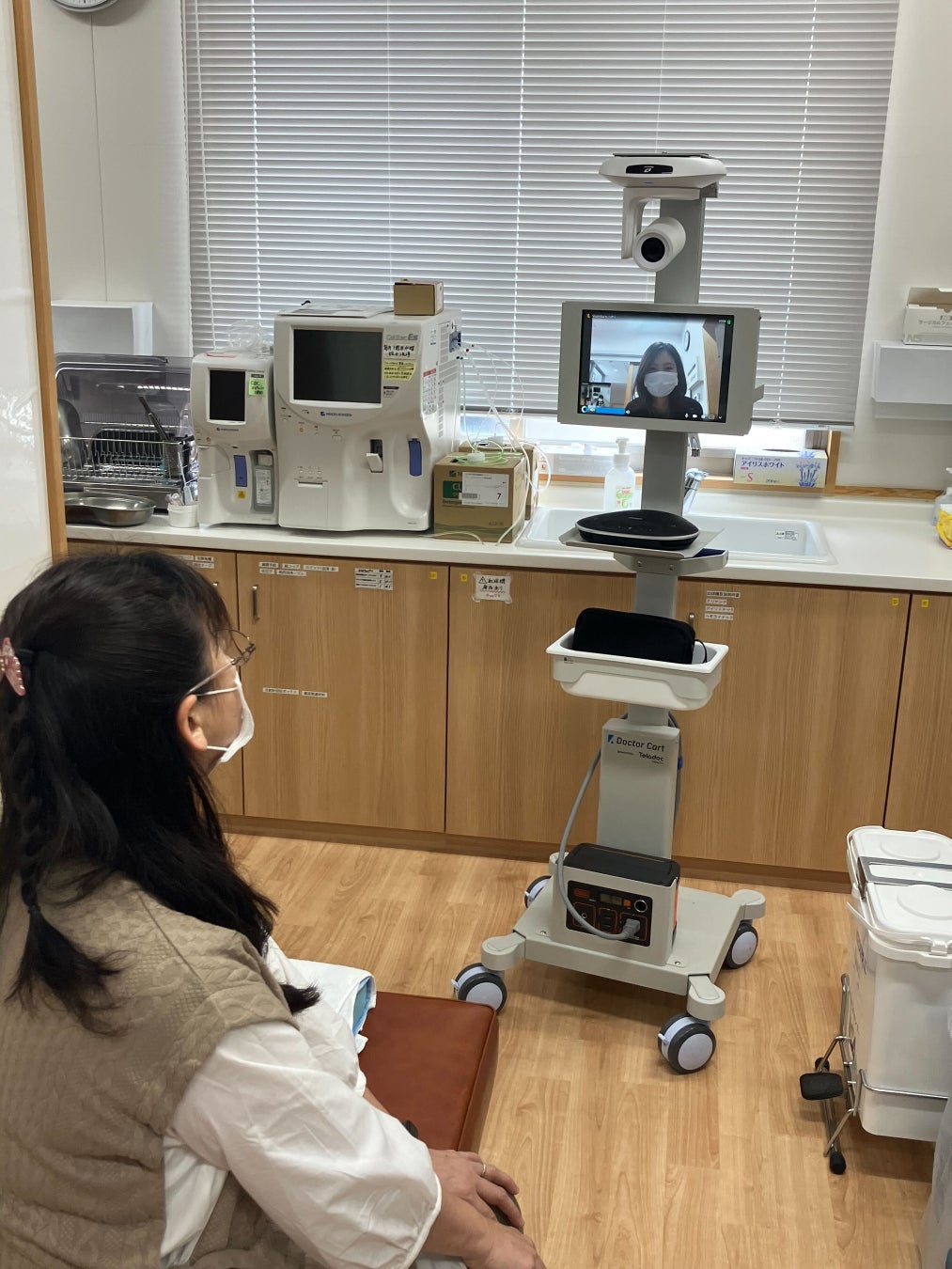 リアルタイム遠隔医療システム「Doctor Cart」(写真奥)を使用する様子