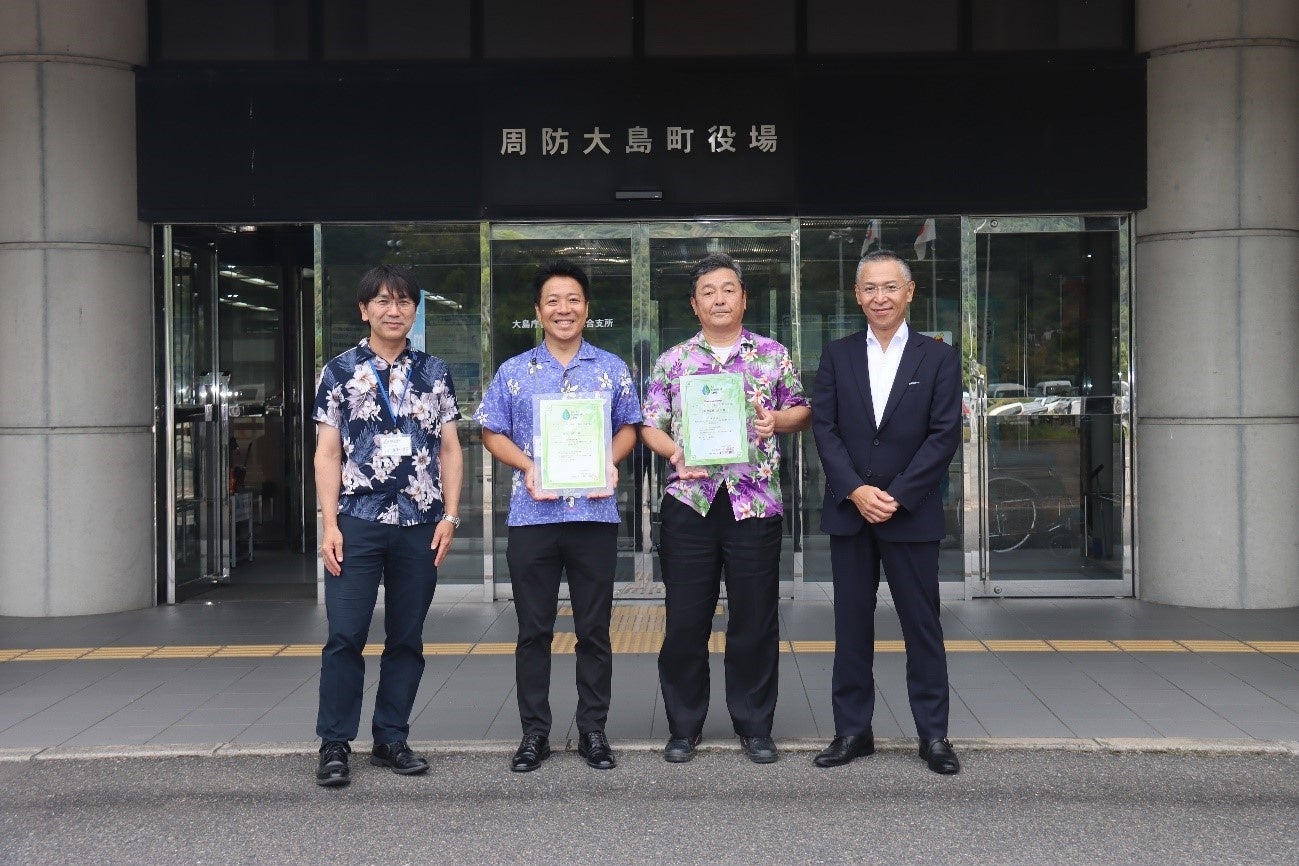 証書授与式後の集合写真。左から星野朋啓教育長（周防大島町教育委員会）、藤本淨孝町長（周防大島町）、佃一郎代表取締役社長（小松物産）、山中光常務取締役国内事業本部長（アストモスエネルギー）。