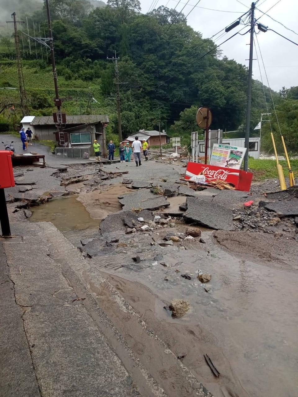 集落を大量の水が襲い道路がめくれ上がっています。