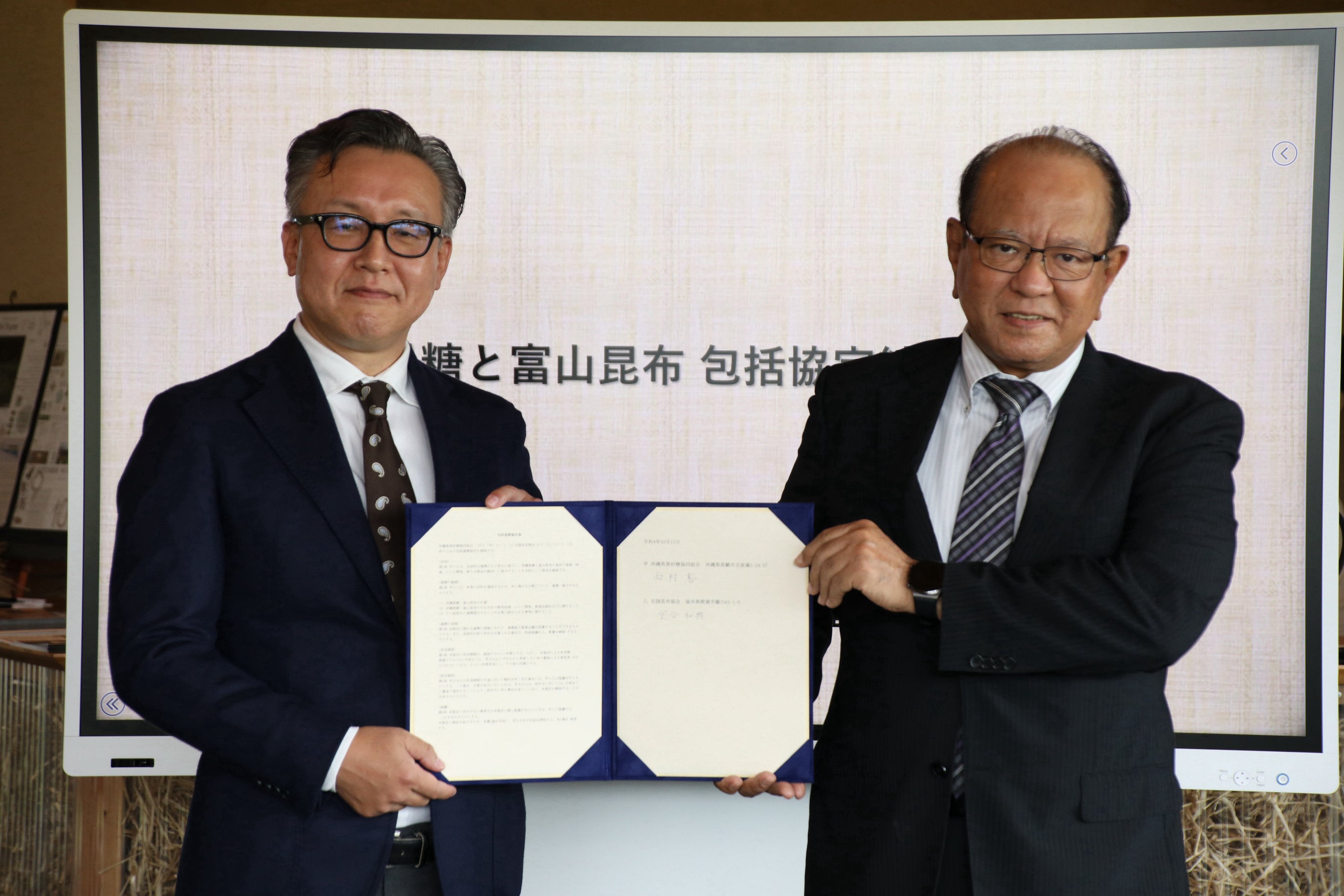 締結式の模様 （左）北陸昆布協会副会長　室谷　和典さん （右）沖縄県黒砂糖協同組合代表理事　西村　憲