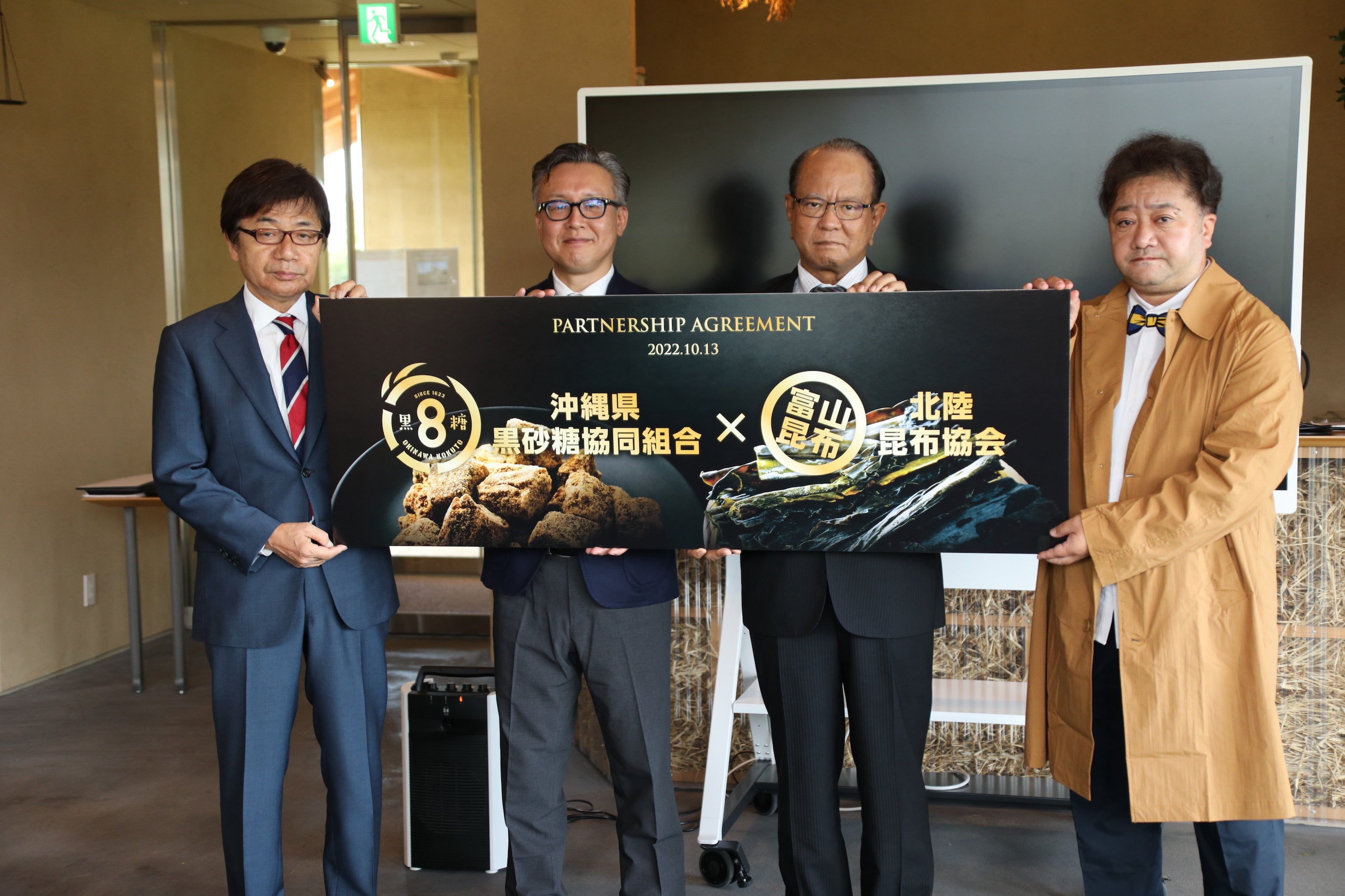 フォトセッション ＊左から カターレ富山　代表取締役社長　左伴　繁雄さん 北陸昆布協会副会長　室谷　和典さん 沖縄県黒砂糖協同組合代表理事　西村　憲 沖縄SV　COO・妙摩 雅彦さん