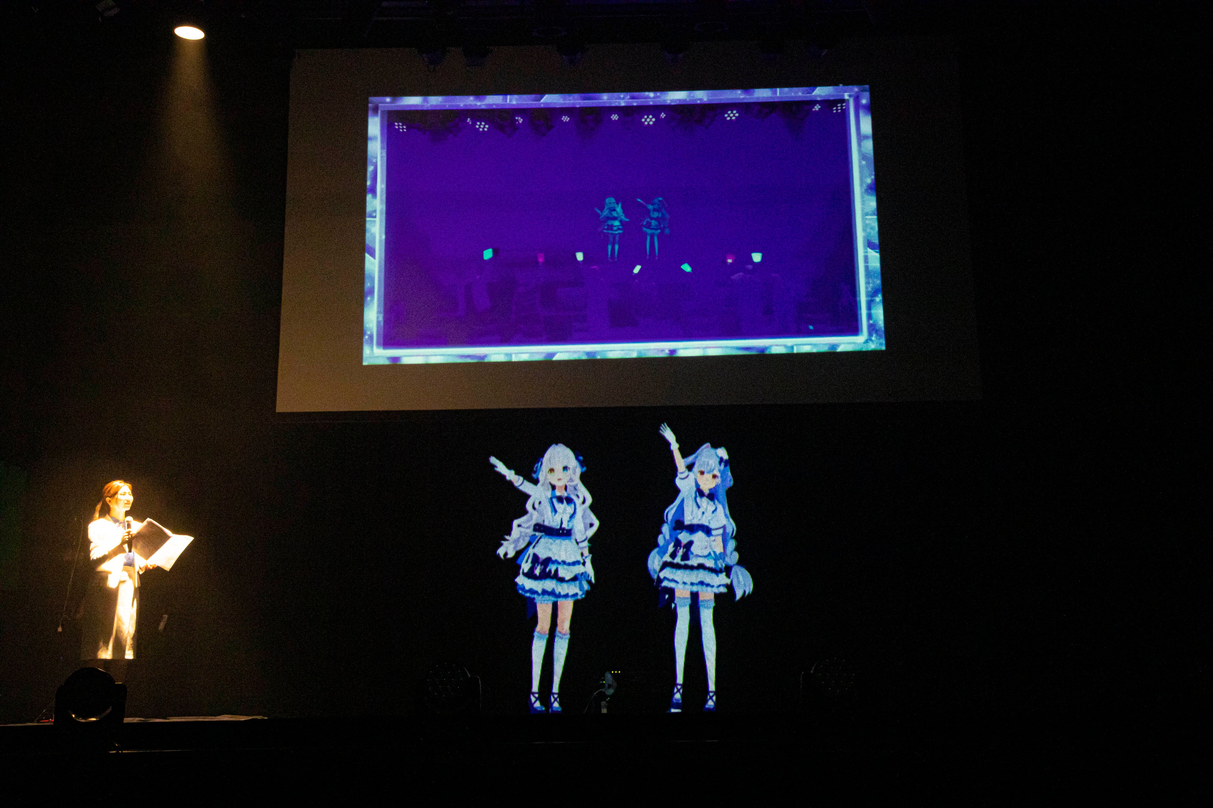 東京Theater Mixa（ステージ）と上海VAPOLLO THEATER（上部中継映像）の二つのステージに同時に出演するNHOT BOT。世界中のステージに同時出演できることを披露。（2022年9月16日Theater Mixaプレス発表会にて）