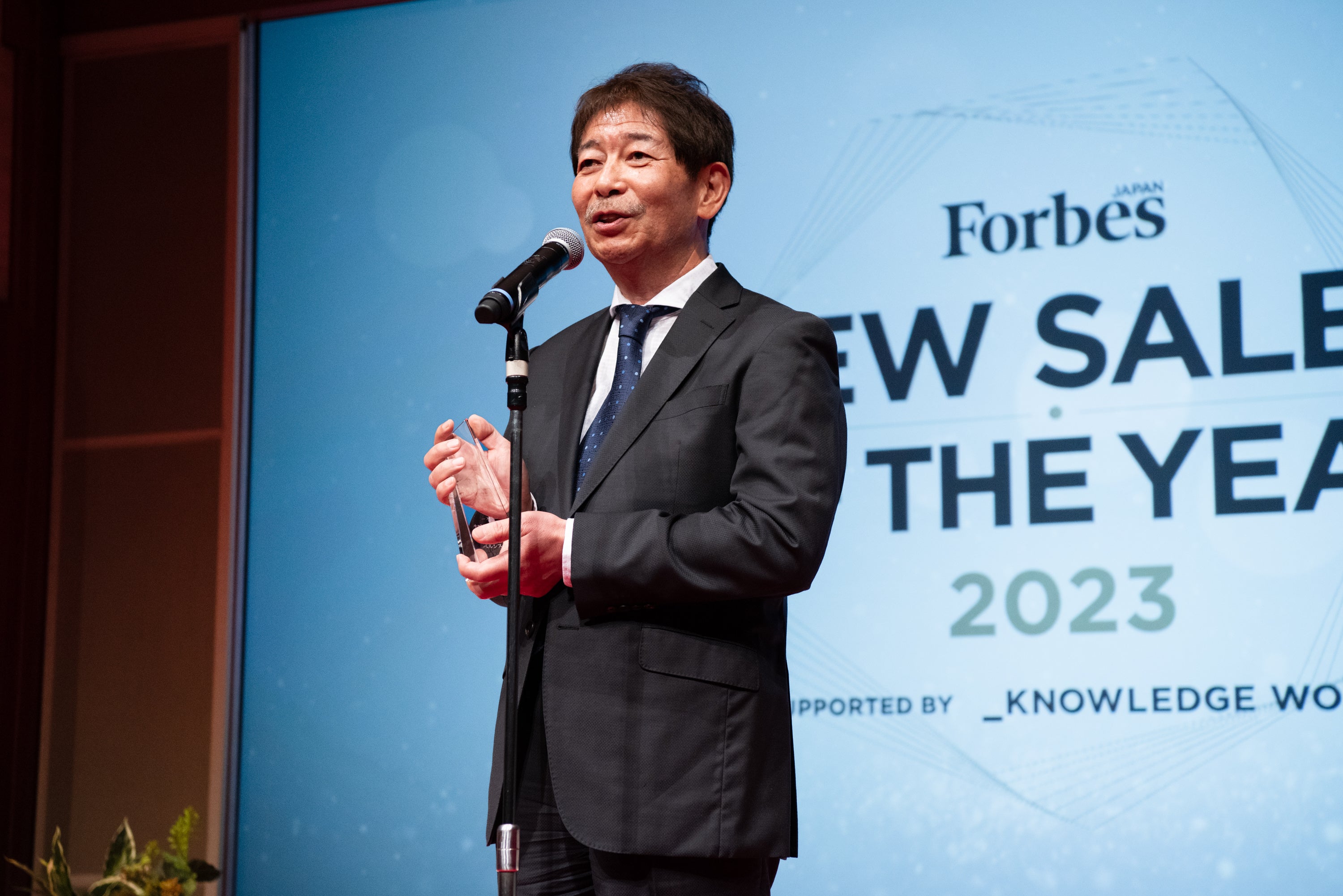 受賞スピーチの様子（当社 常務執行役員 兼 業務統括本部 本部長 横田 純平）