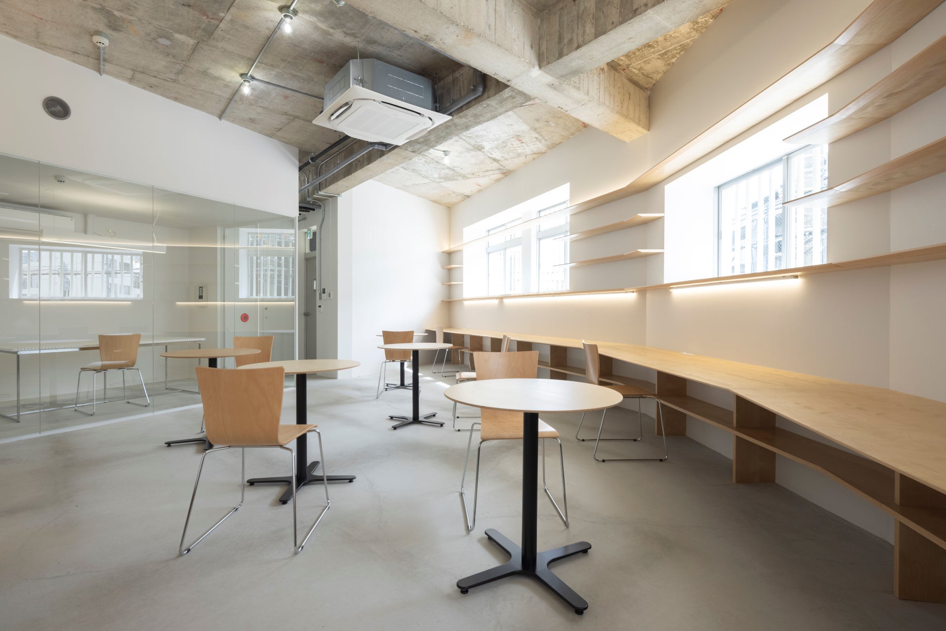 2階 オフィス:作業に集中できるよう窓際にカウンター、中央部に小さな丸テーブルを配置 © Kaoru Yamada