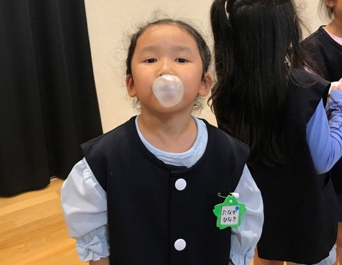 フーセンガムをふくらませる園児