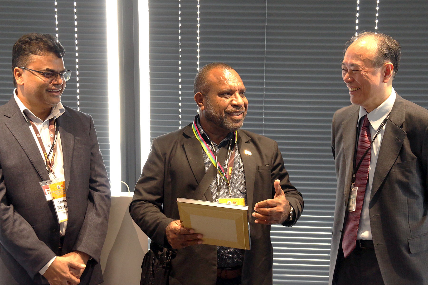 東京通信大学 情報マネジメント学部学部長 加藤泰久教授 と談笑するパプアニューギニア教育省 通信教育担当部長、 広域通信教育機関（FODE）校長