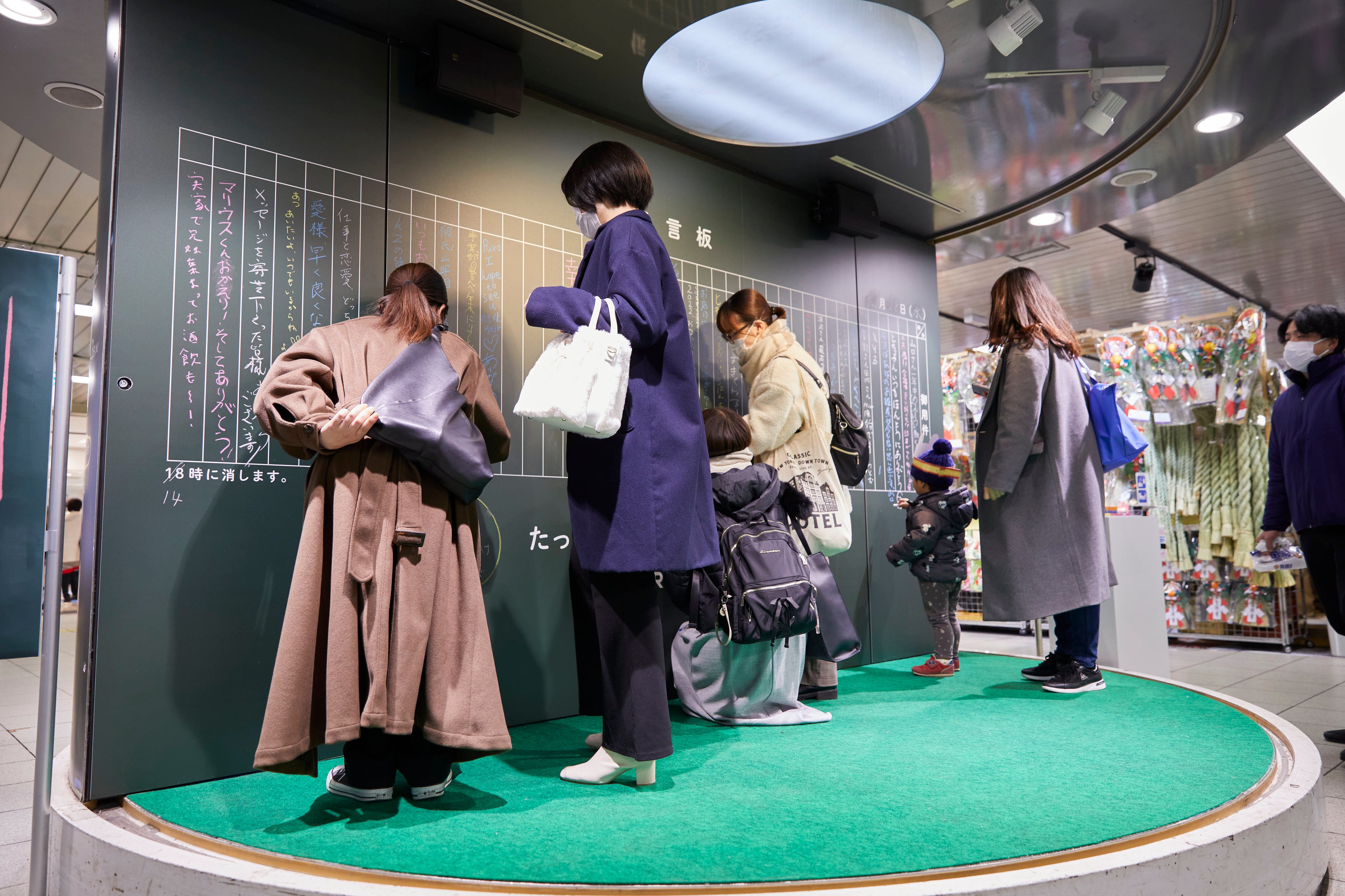 池袋駅に設置した大型伝言板に思い思いのメッセージをつづる様子。