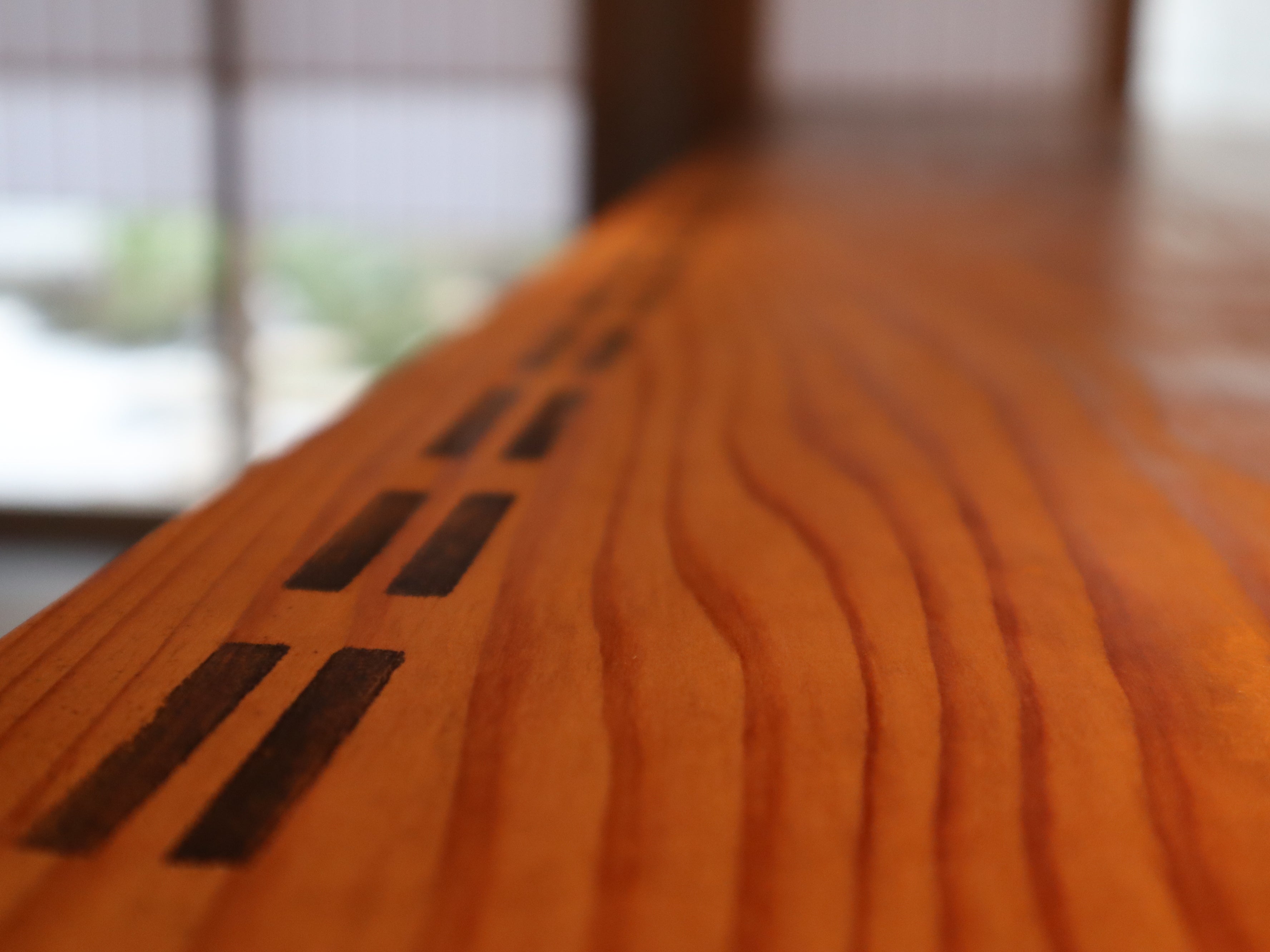 カウンター　京都の友禅染で使用されていた、貴重なもみの木で作られた道具を譲り受けて加工。反物を置くガイドとなる黒い線が残る