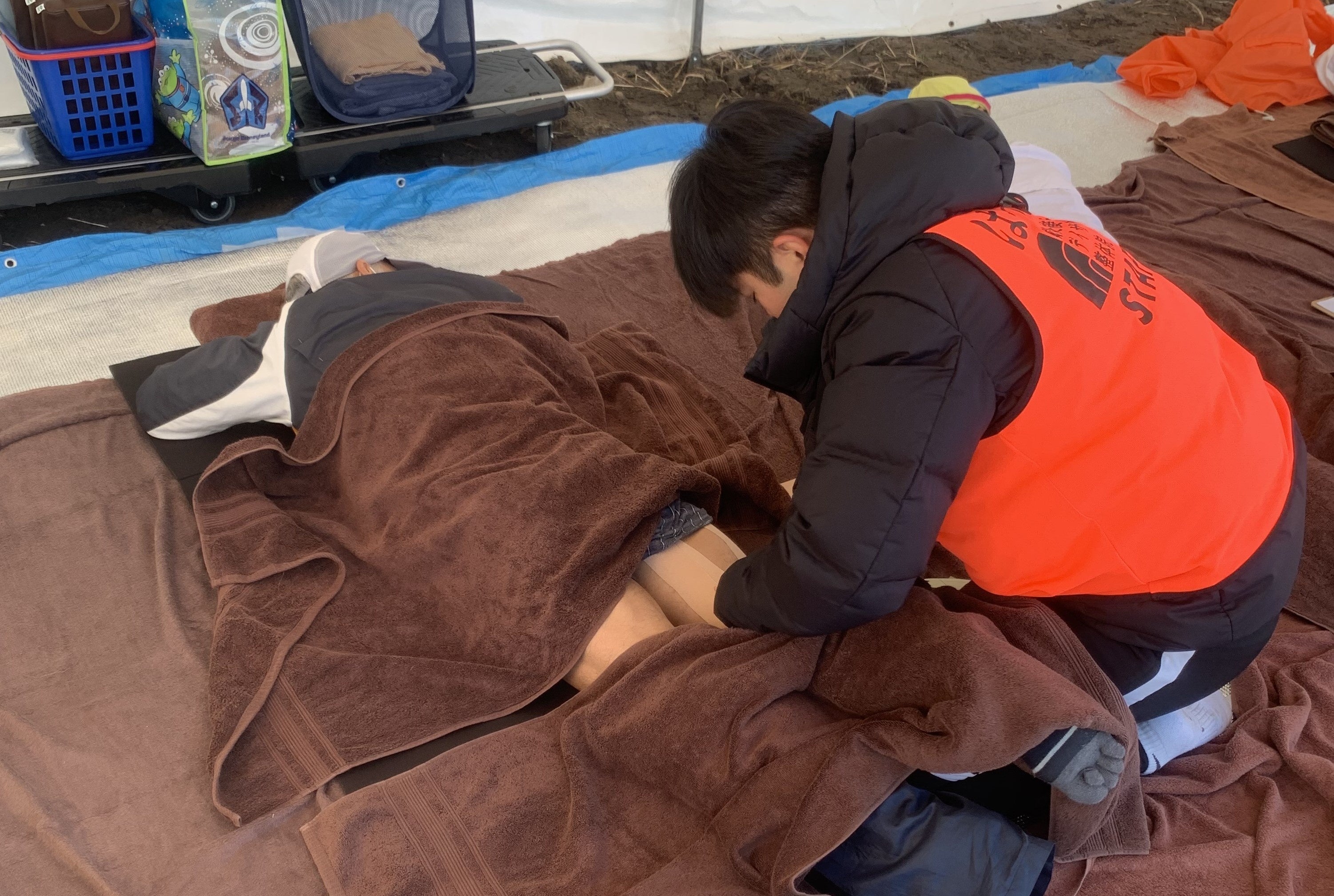 大会中に肉離れをしてしまったランナーにテーピングをしている写真