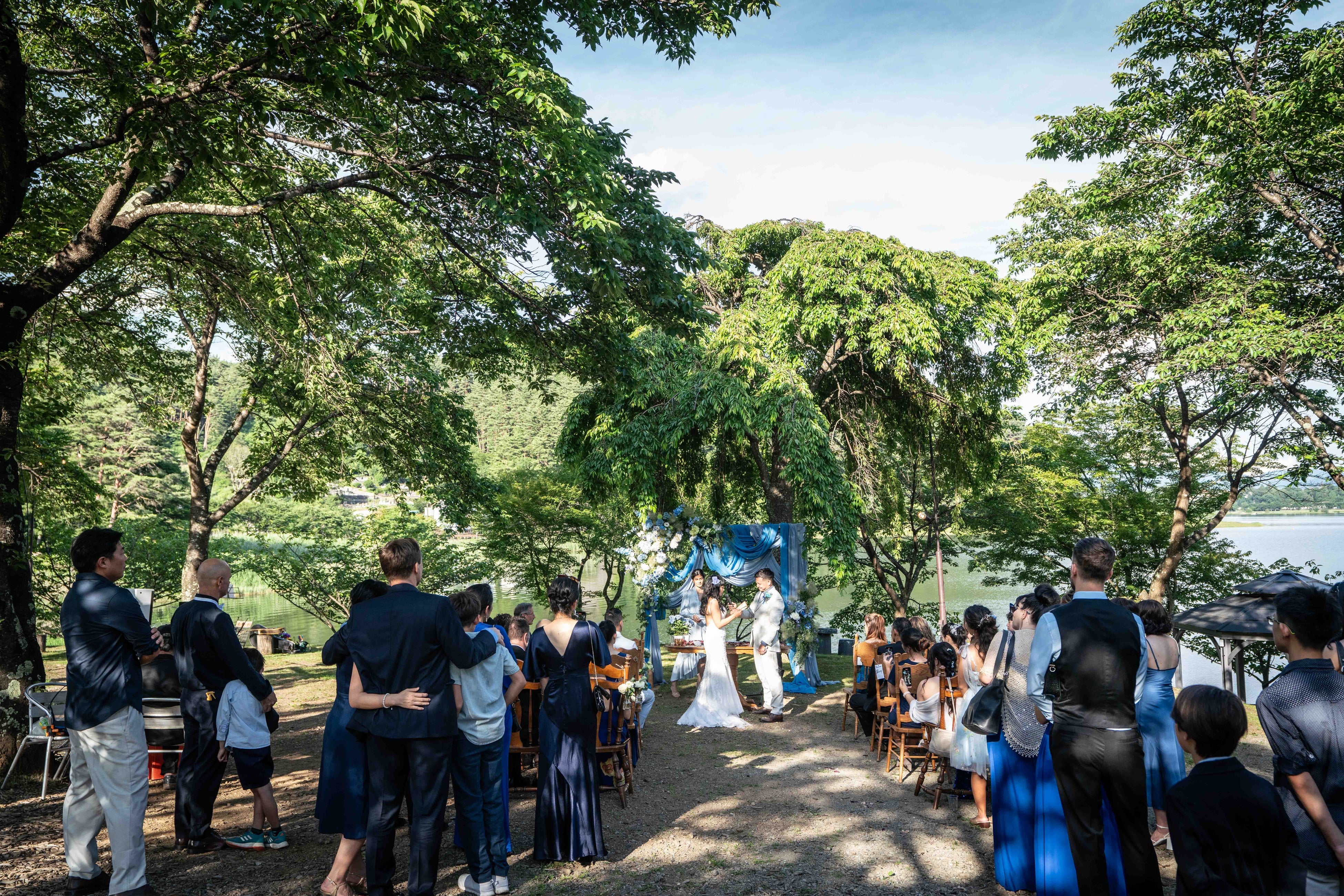 大勢のゲストと行う湖畔庭園でのウェディング　©小林正嗣