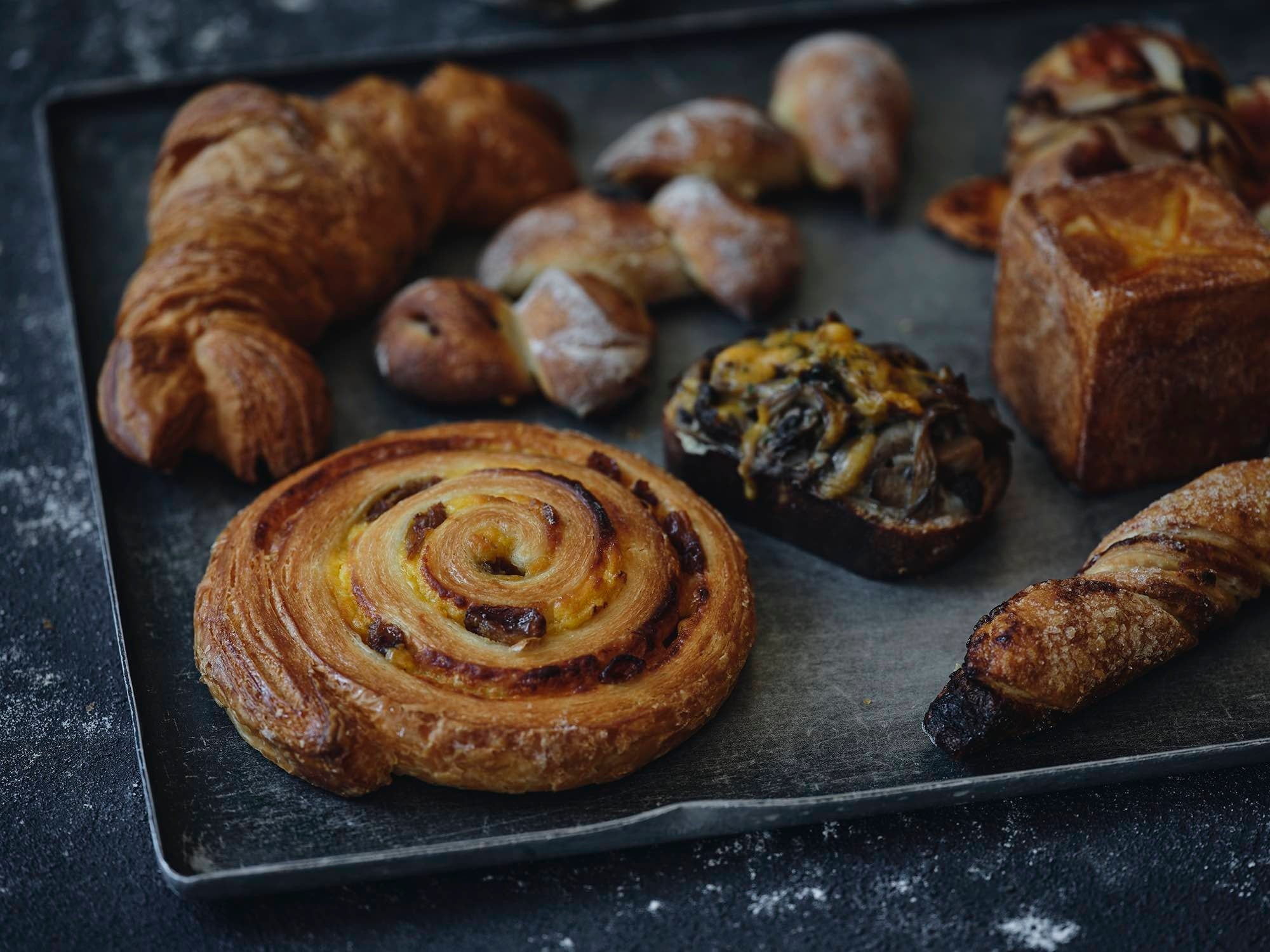 左上から時計回りに）クロワッサン　¥292、ベーコンエピ　¥378、オニオン＆チーズ　¥421、パン オ フロマージュ　¥454、ル・サクリスタン　¥324、キノコソテーのタルティーヌ　¥475、エスカルゴ レザン　¥346