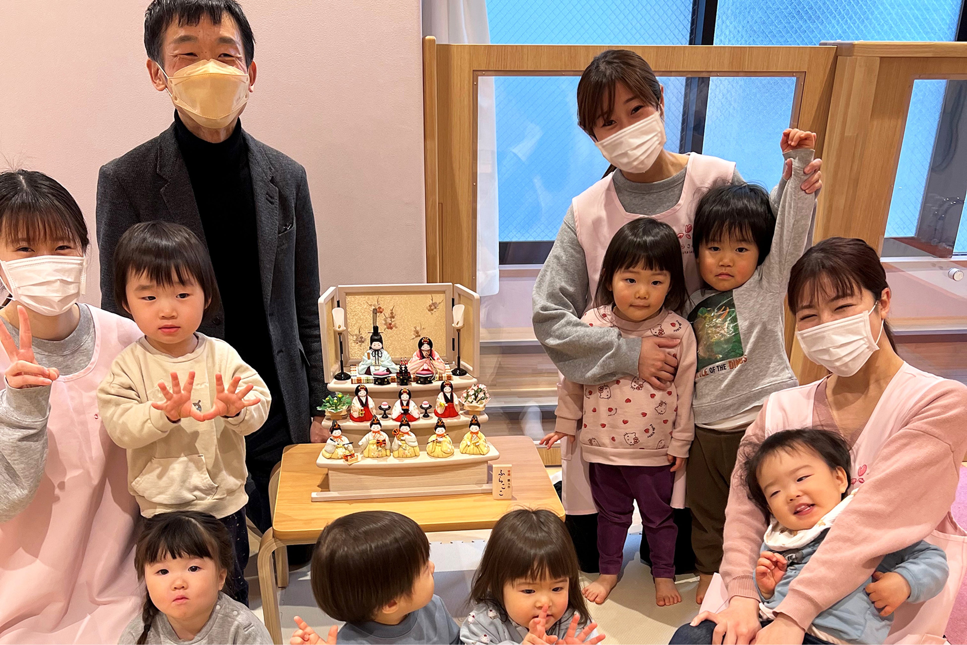 雛人形の飾り付けを終えて、園児たちや職員の方々と一緒に　※保護者の方々の許可を得て掲載