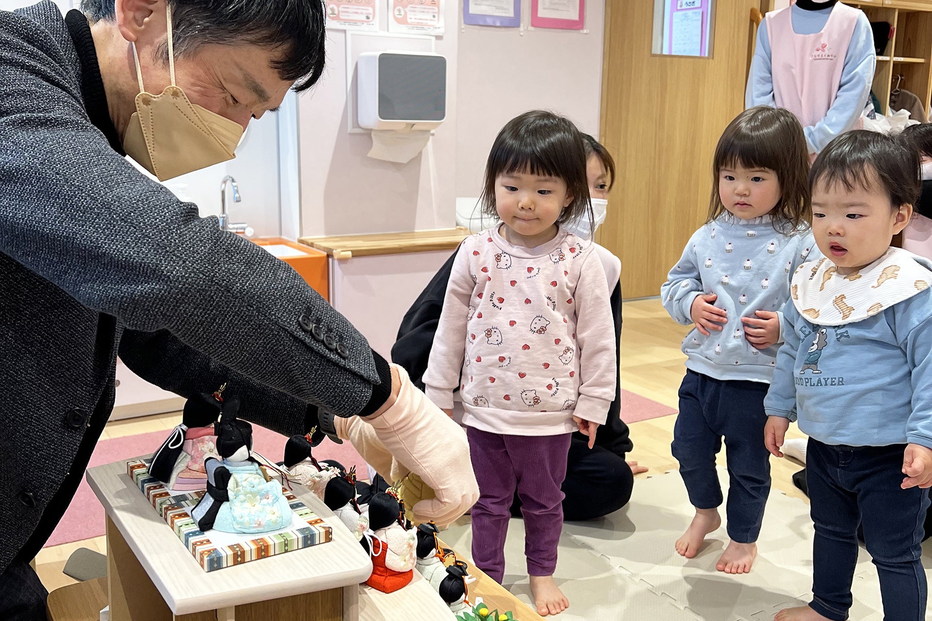 興味津々な様子で雛人形の飾り付けを見つめる園児たち　※保護者の方々の許可を得て掲載