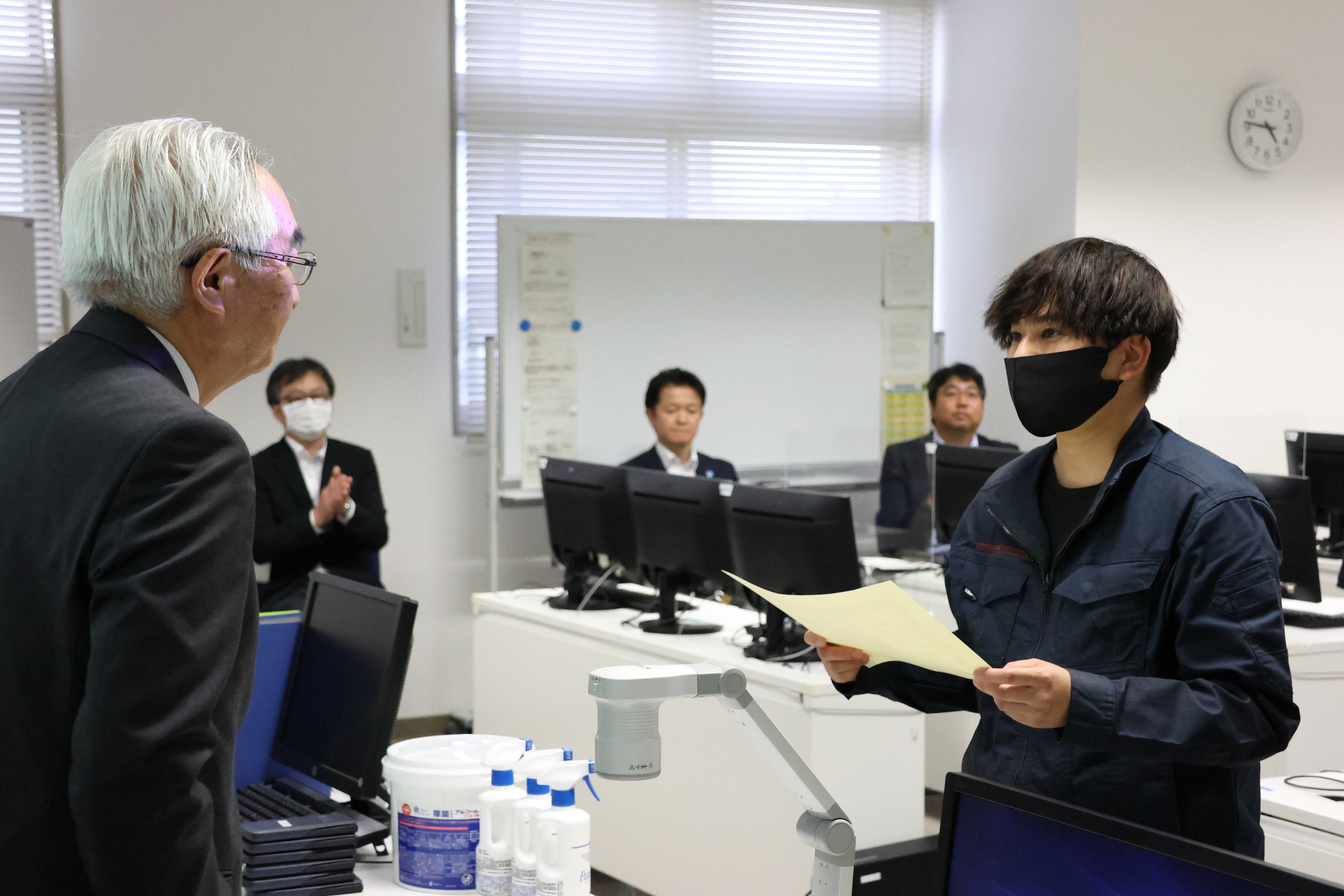 修了証書を手渡すテクノコム社長・大江（写真左）と受け取る受講生（写真右）