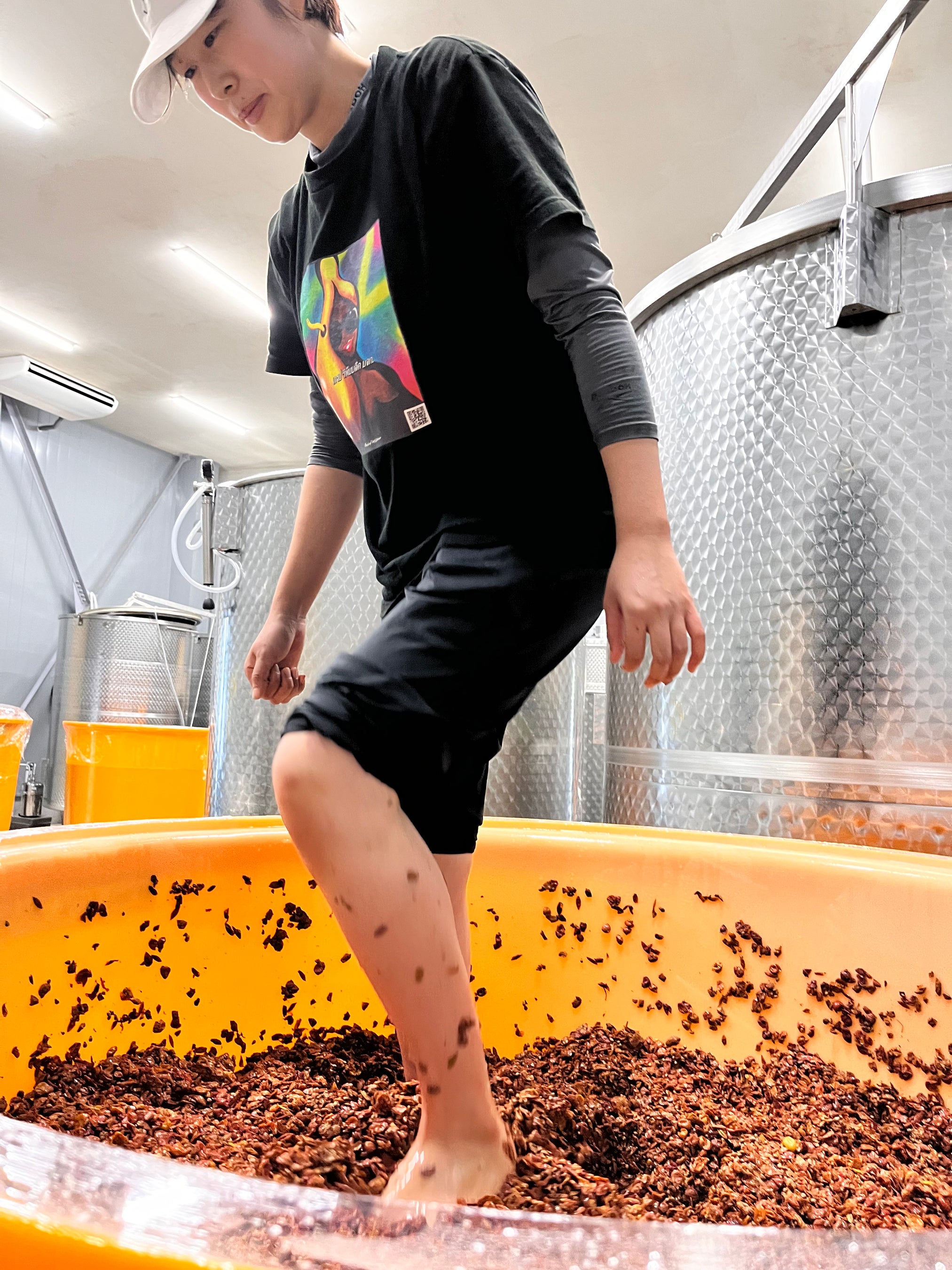 樹脂タンクに入れた搾りかすを脚で押し潰して発酵を促す。