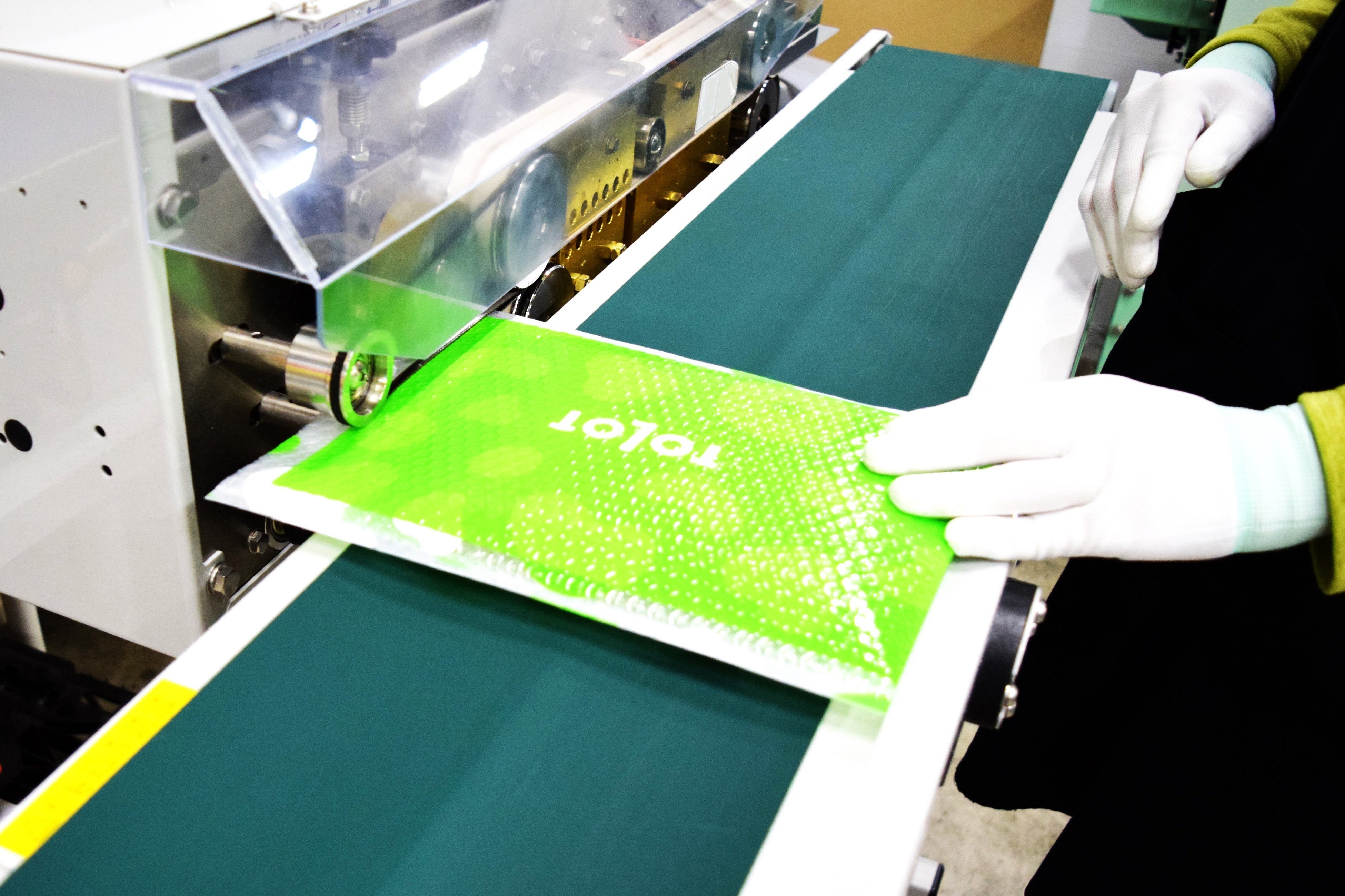 梱包作業　シーラーで封印