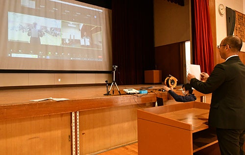 協定書を掲げる松葉校長