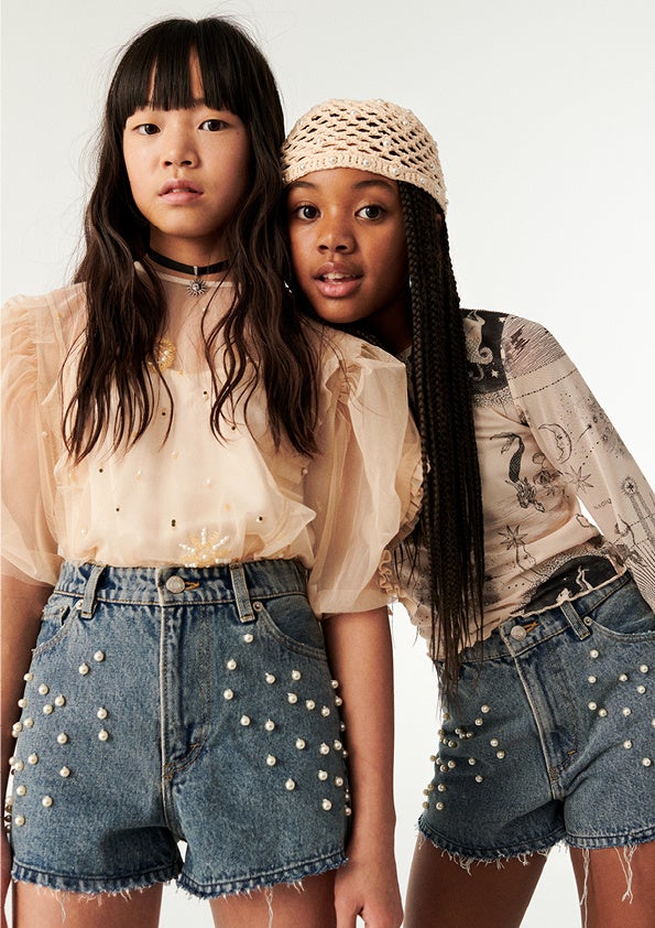 (左)ビーズモチーフフリルブラウス￥5,999 ビーズデニムショートパンツ￥4,999 ペンダントネックレス 2本セット￥2,999 (右)プリントメッシュトップス￥2,999 ビーズデニムショートパンツ￥4,999 ビーズクロッシェキャップ￥3,999