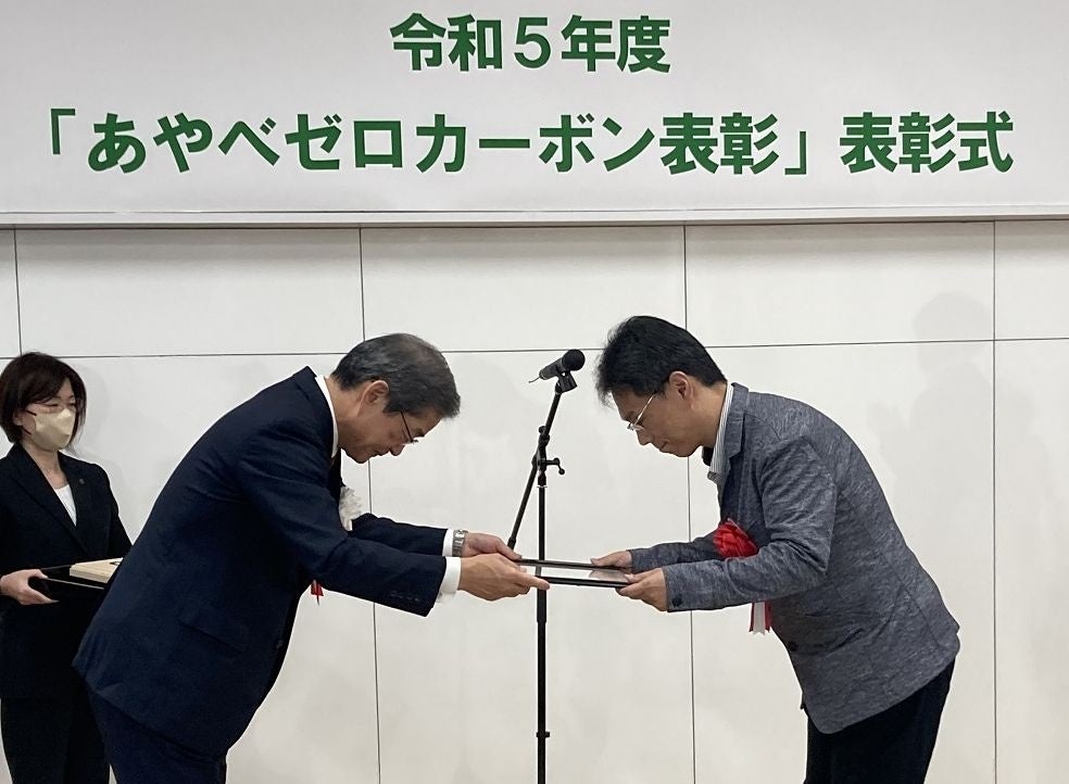 山﨑 善也綾部市長（左）から表彰状を受け取る 綾部工場 生産管理部 部長 河野 雅行(右)