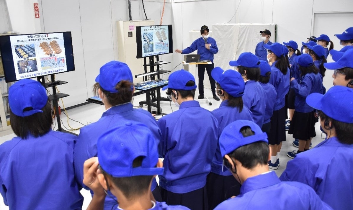 工場内で製造する「金型部品」についての説明を受ける生徒たち