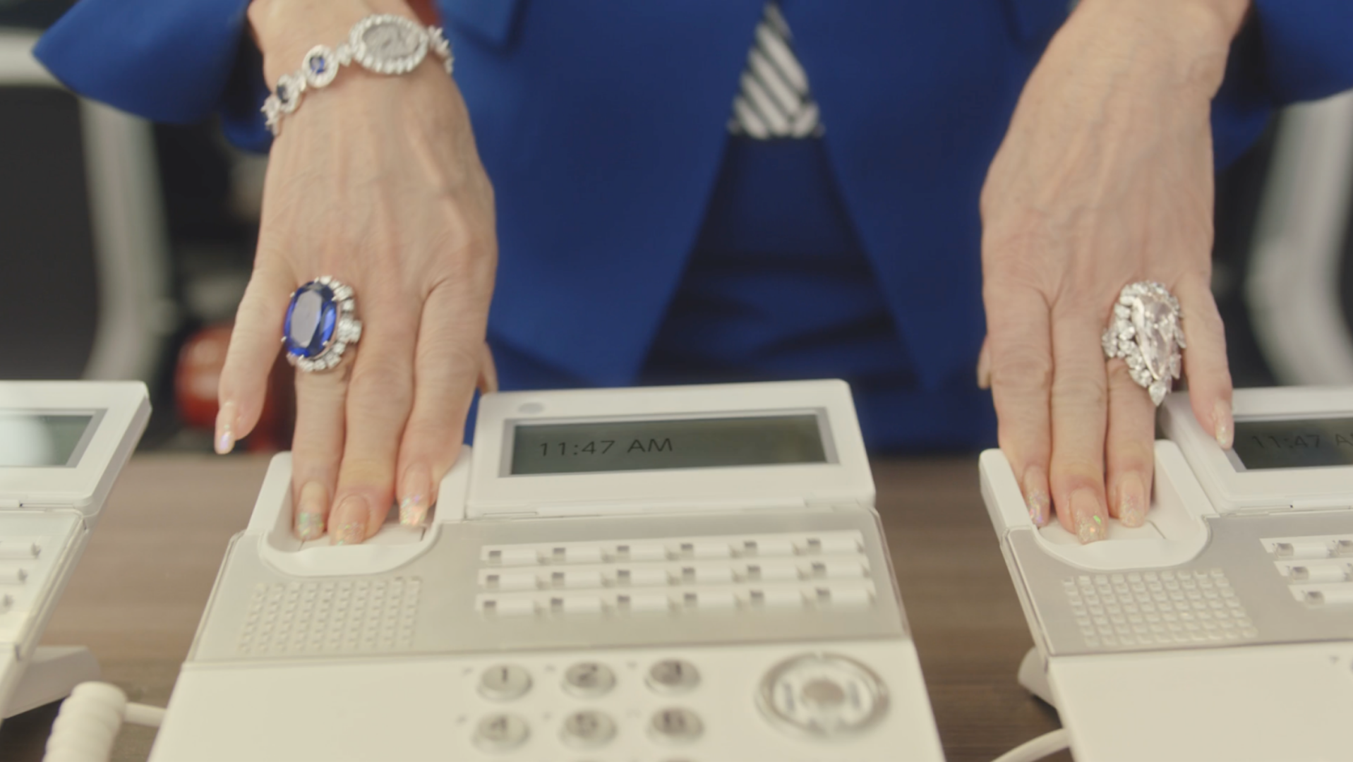 突然、ゴージャスなアクセサリーを纏った謎の人物が受話器を止める