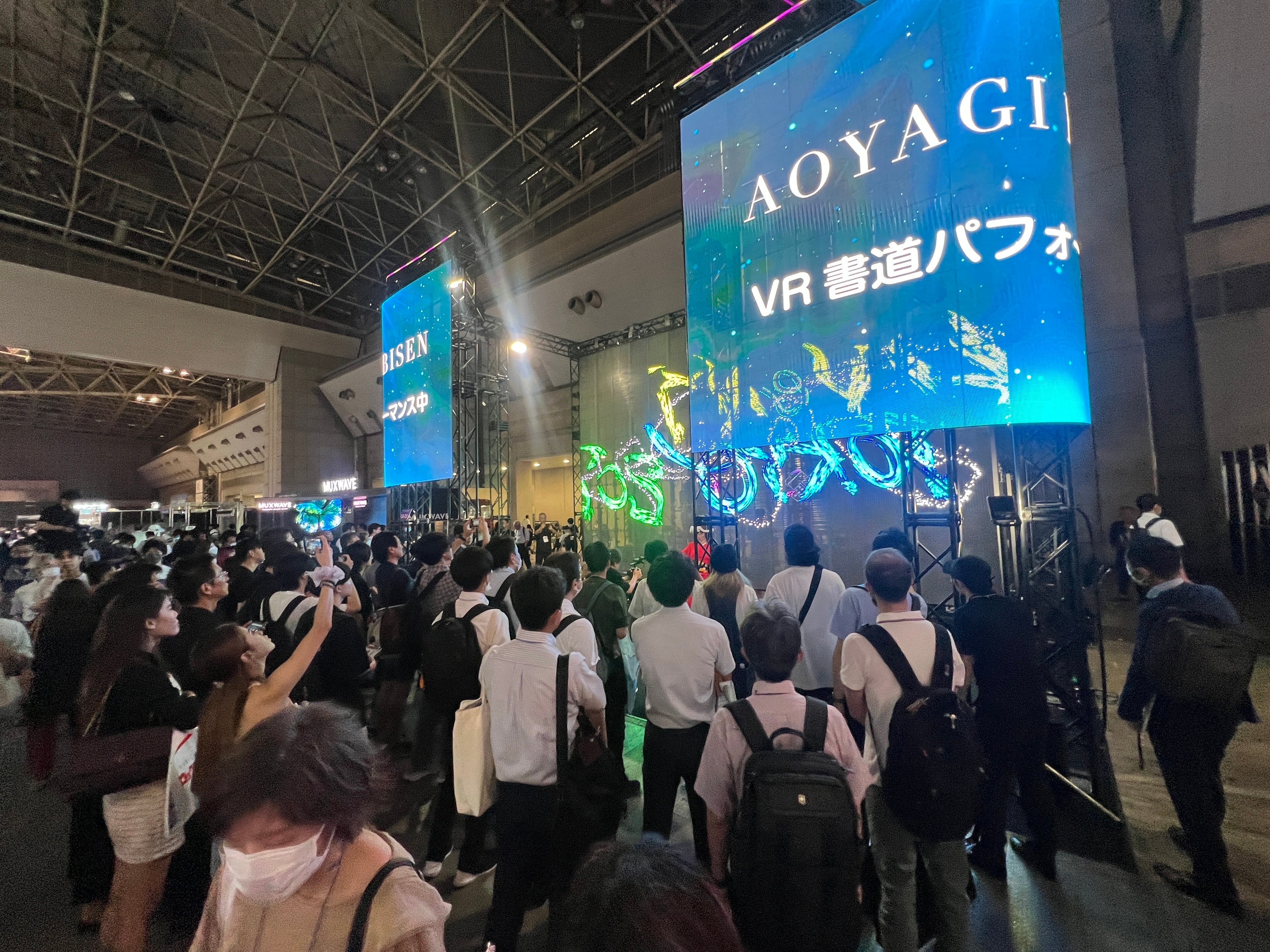 大画面を用いたVR書道ライブイベントは多くの人がカメラを構えて撮影していた