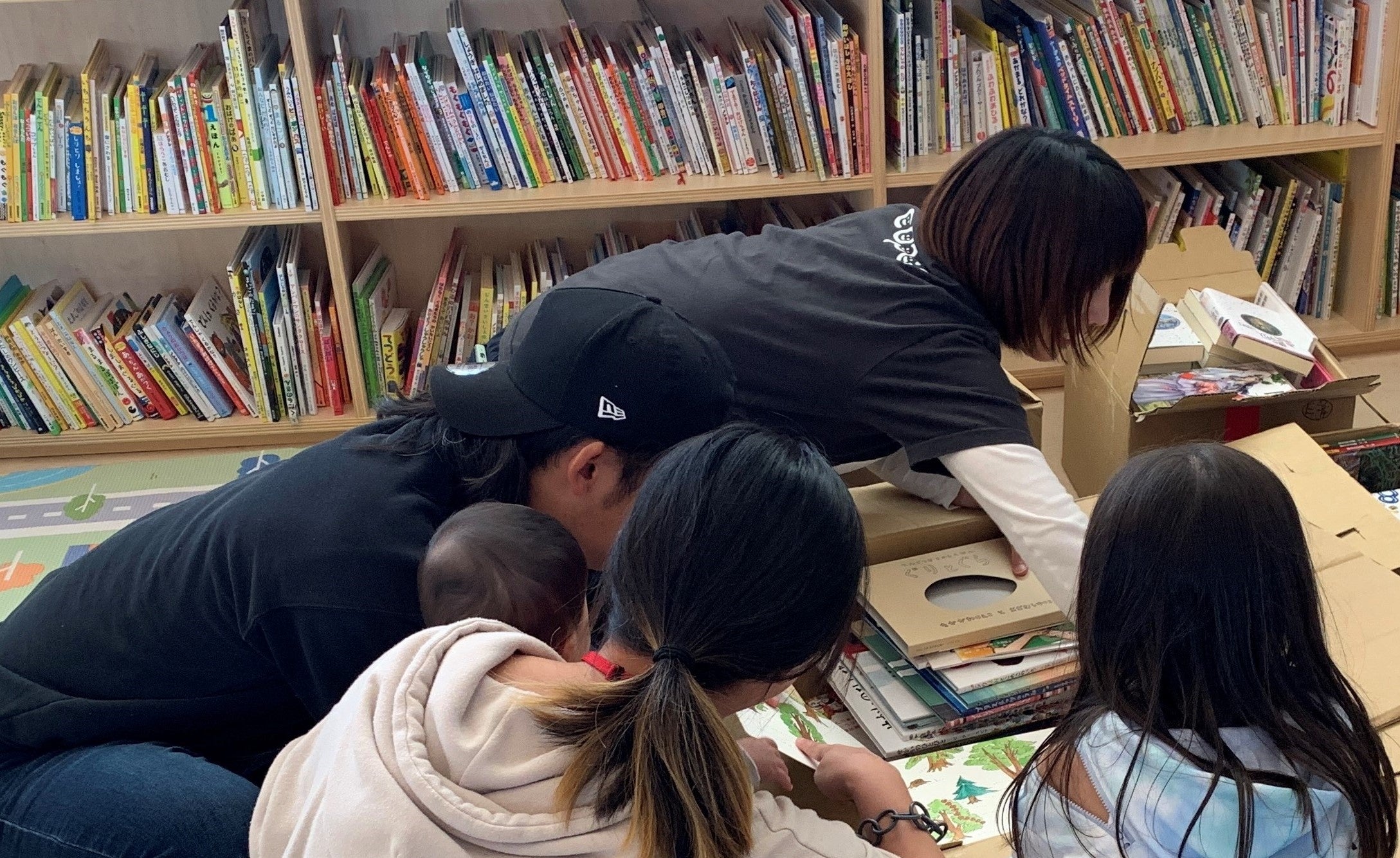 寄贈された絵本や児童書を選んでいる親子の様子（コパルにて）