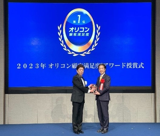 オリコン（株）の小池代表取締役社長（左）より、当社代表取締役社長CEOの勝本にトロフィーが授与されました