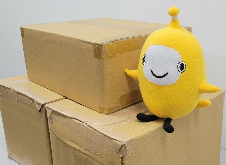 寄付した備蓄防災食品の一部と保険クリニックキャラクターのIQくん