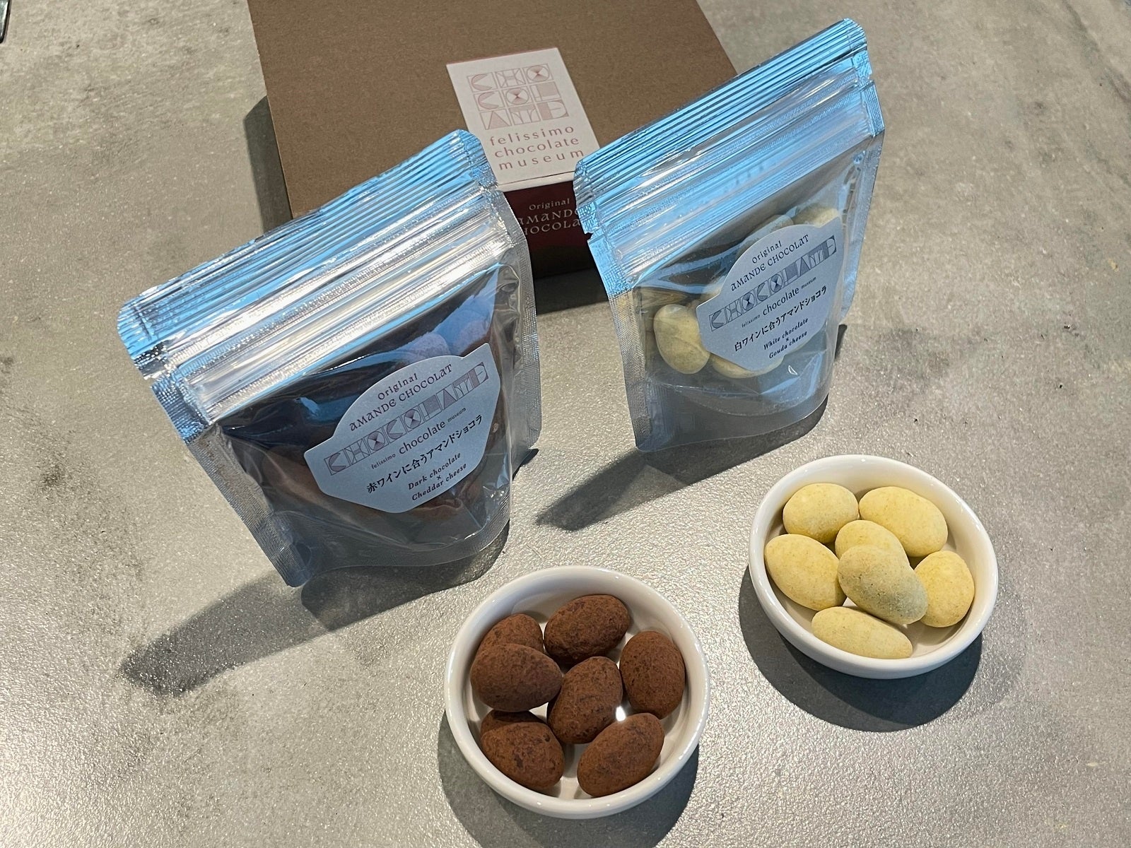 左:ダークチョコに〈チェダーチーズとカカオとブラックペッパーパウダーをまとったアマンドショコラ〉、右:ホワイトチョコに〈ゴーダチーズとローズマリーパウダーをまとったアマンドショコラ〉